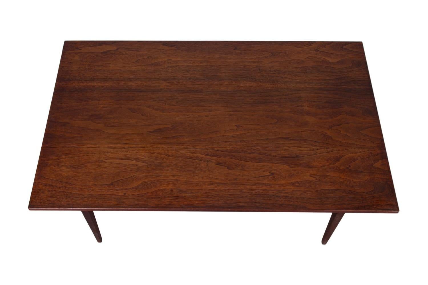 Une belle table basse moderne du milieu du siècle. La longueur parfaite pour accompagner un canapé, en très bon état. Avec un magnifique plateau en noyer, une influence scandinave et des lignes simples. La table repose sur des pieds robustes et