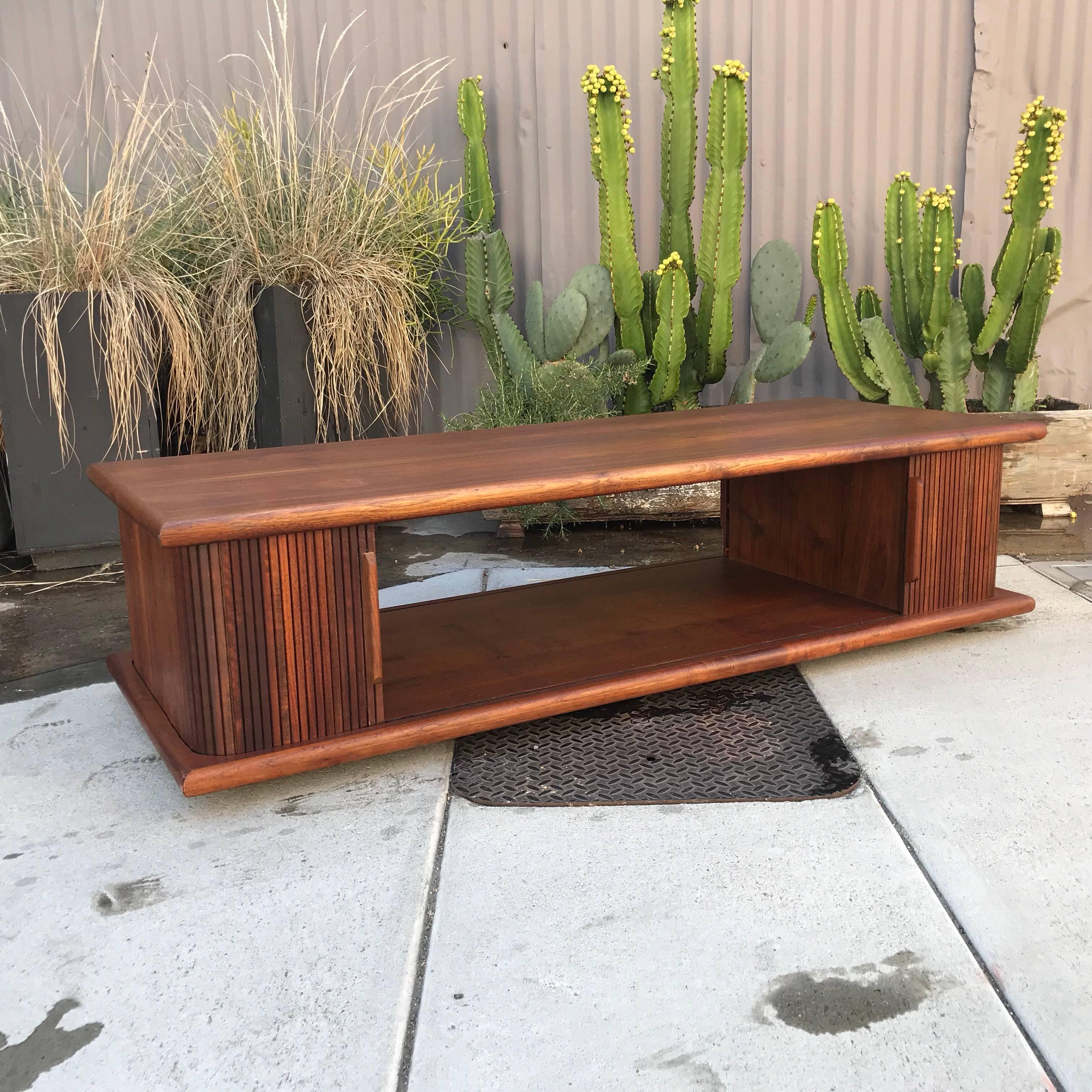For your consideration a Mid-Century Modern walnut coffee table with tambour doors.
Unmarked. The USA, circa 1960s. 
Dimensions: 15 1/4