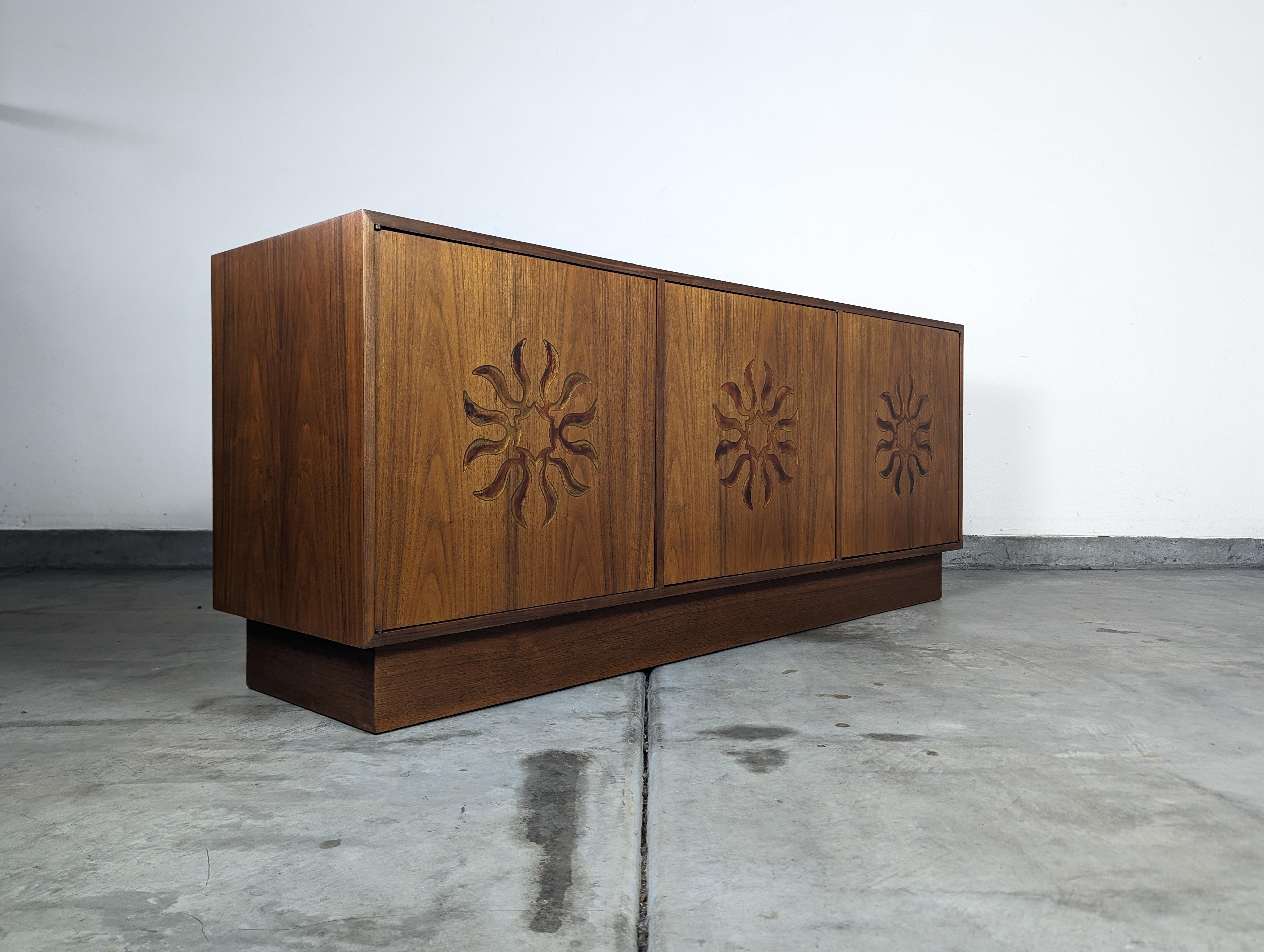 Discover the epitome of mid-century elegance with this vintage walnut credenza, attributed to the esteemed Monteverdi Young and meticulously crafted by Cal Mode in Southern California during the 1960s. This piece is a true testament to the era's