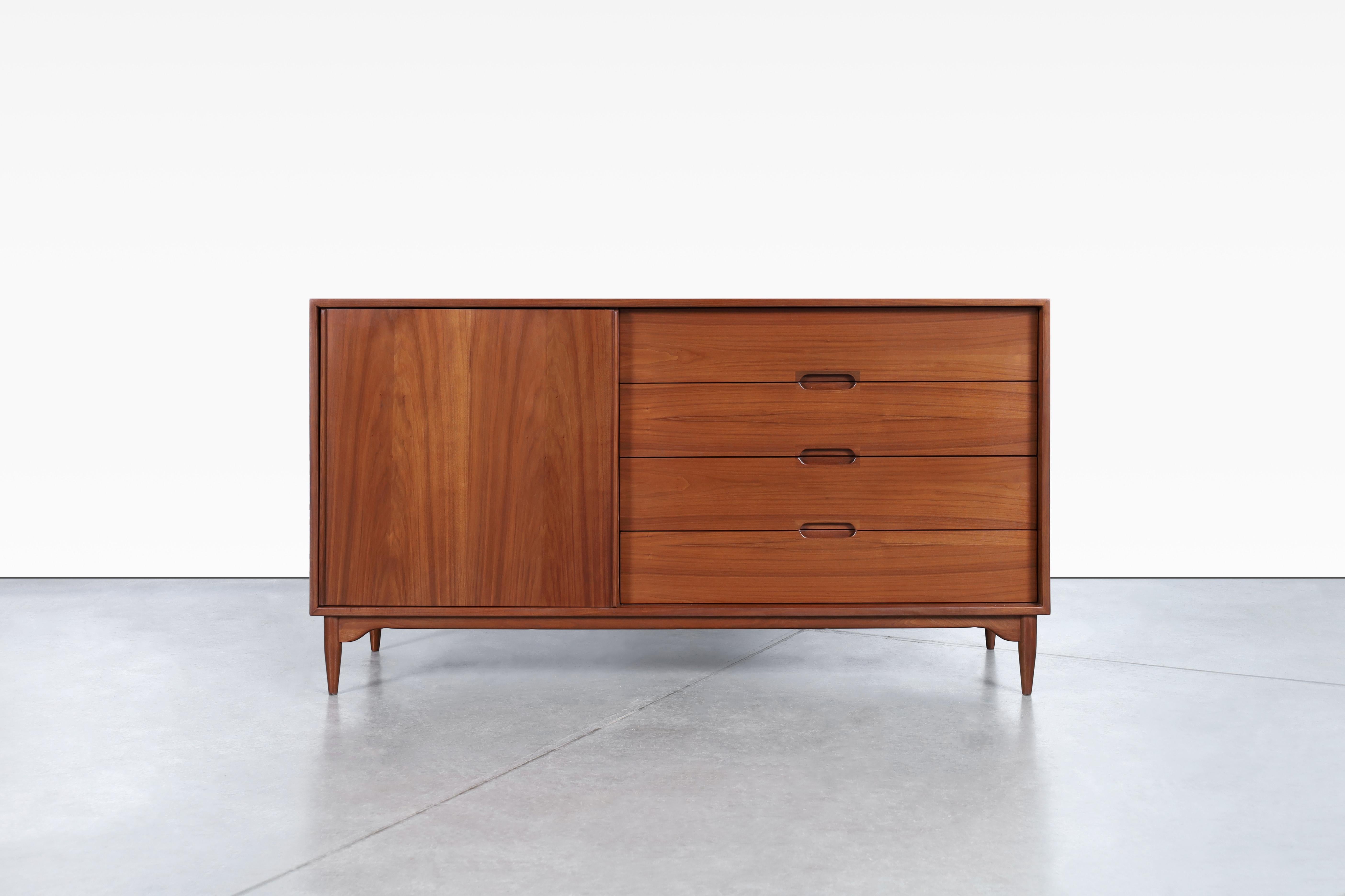 Stunning mid-century modern walnut credenza designed by John Keal for Brown Saltman in the United States, circa 1950s. Features a beautiful and sculptural walnut base lending an air of modernism to the entire piece. Its sinuous curves and organic