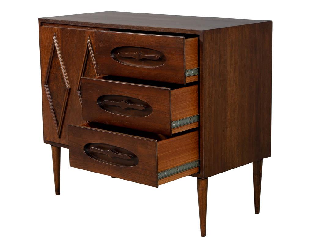 Classic midcentury cabinet with an ingenious sliding door which conceals 3 matching drawers for a total of 6 drawers which provide practical storage. American made from rich walnut.