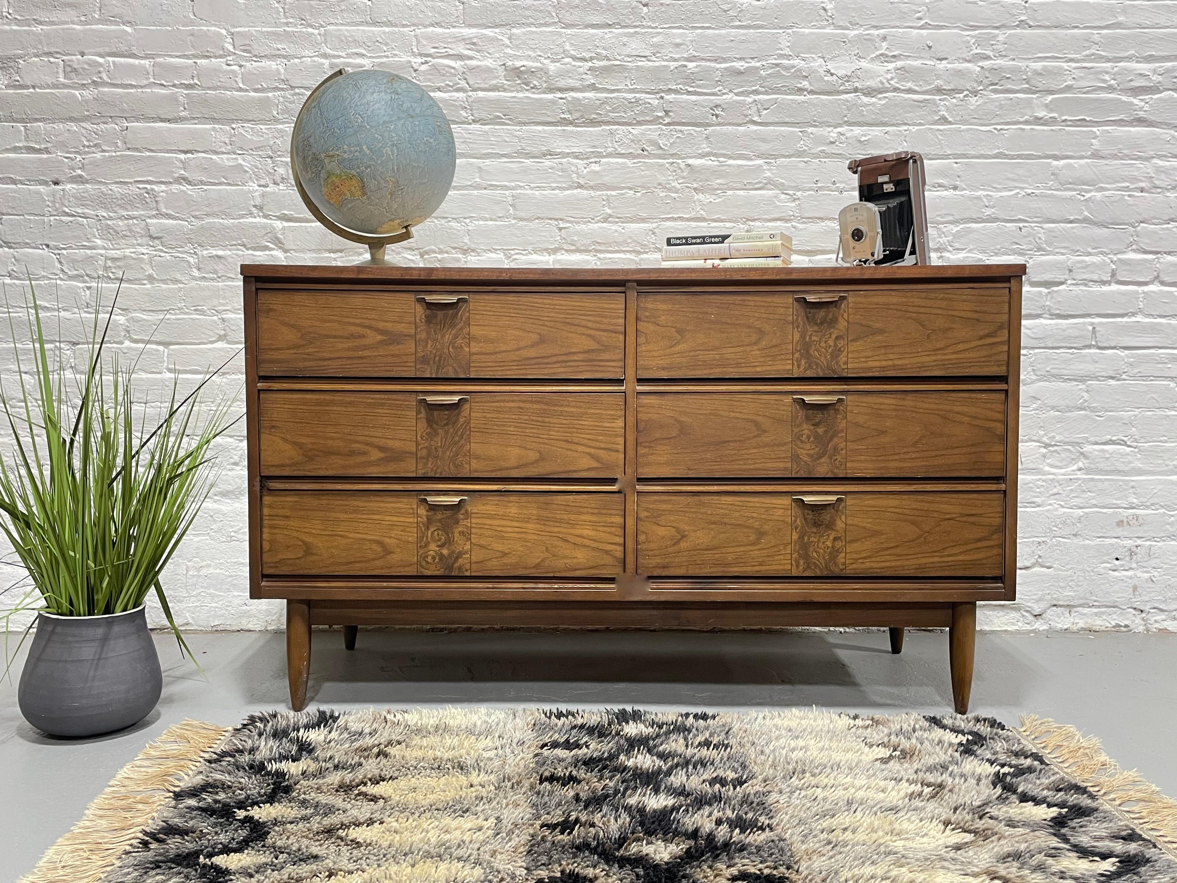 Mid Century Modern Walnut Credenza / Dresser consisting of six spacious drawers for all your clothing storage needs. The dresser is highlighted by a lovely decorative design on each drawer front.  Lovely vintage condition with a newly refinished