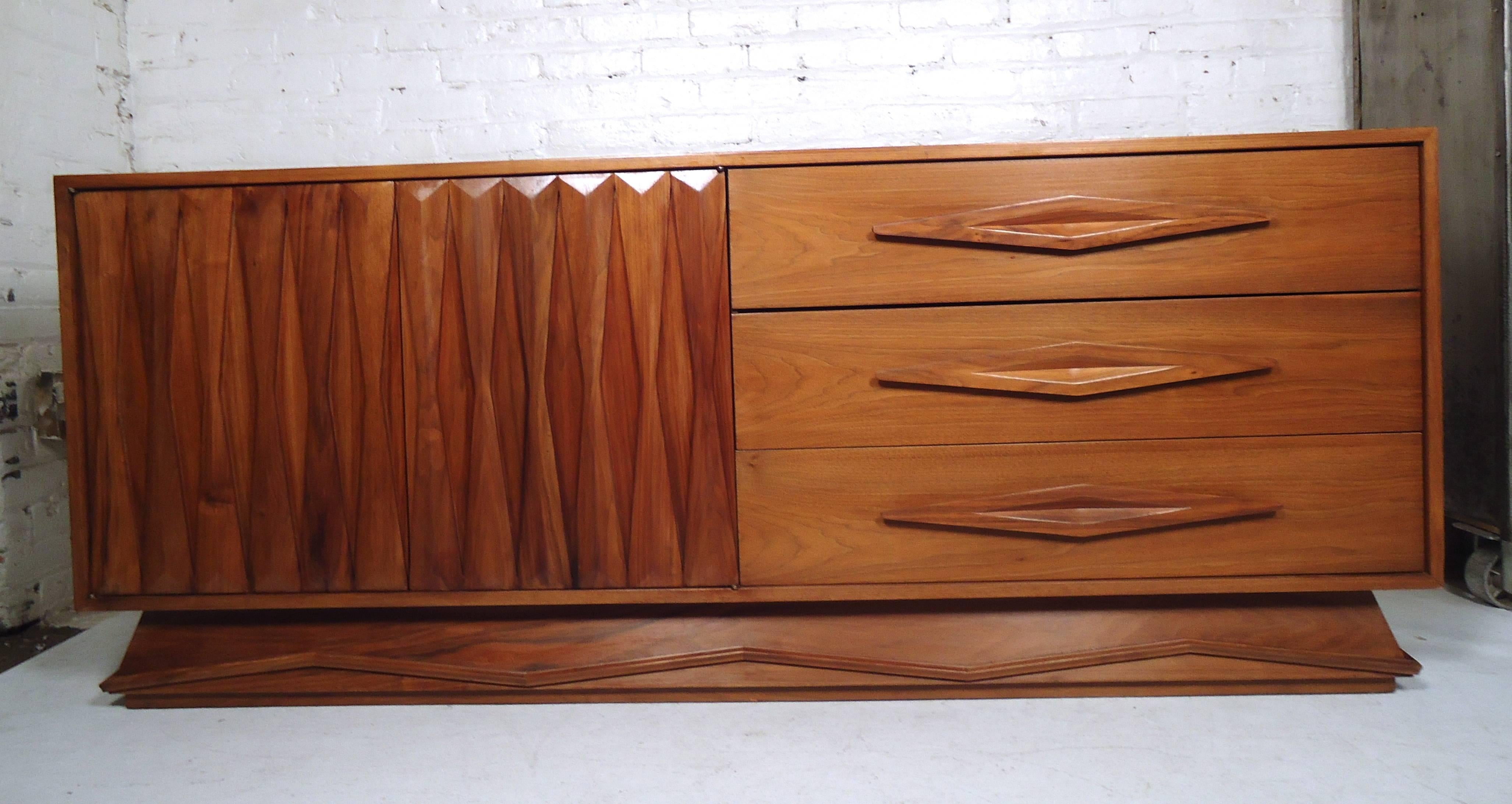 Vintage modern walnut credenza featuring many sculpted wood detail throughout, three drawers and a spacious storage compartment.

(Please confirm item location - NY or NJ - with dealer).