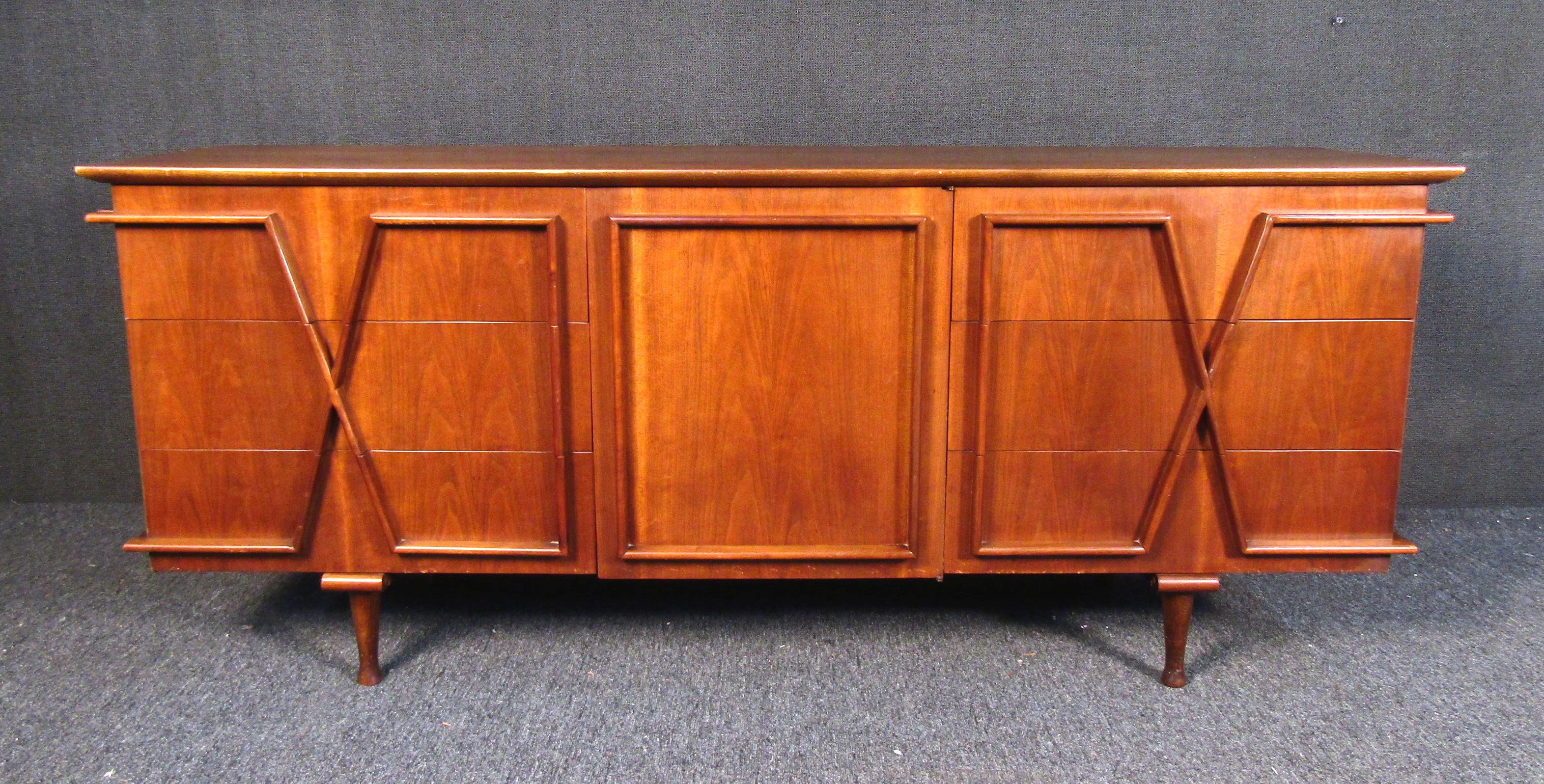 Vintage modern credenza featuring a sculpted design front in rich walnut wood grain.
This dresser has six larger drawers with three smaller center drawers.

(Please confirm item location - NY or NJ - with dealer).