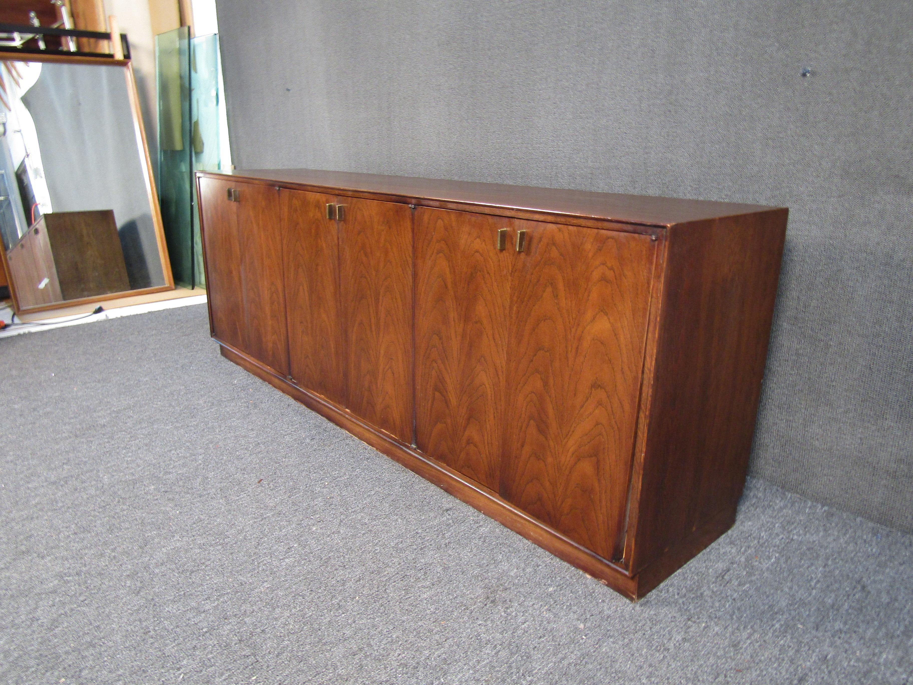 A vintage modern walnut dresser with a beautiful grain pattern. Complete with dove-tailed drawers, brass pull handles and 3 storage drawers with dividers. This piece is sure to look great in any home/office setting. 

(Please confirm pickup