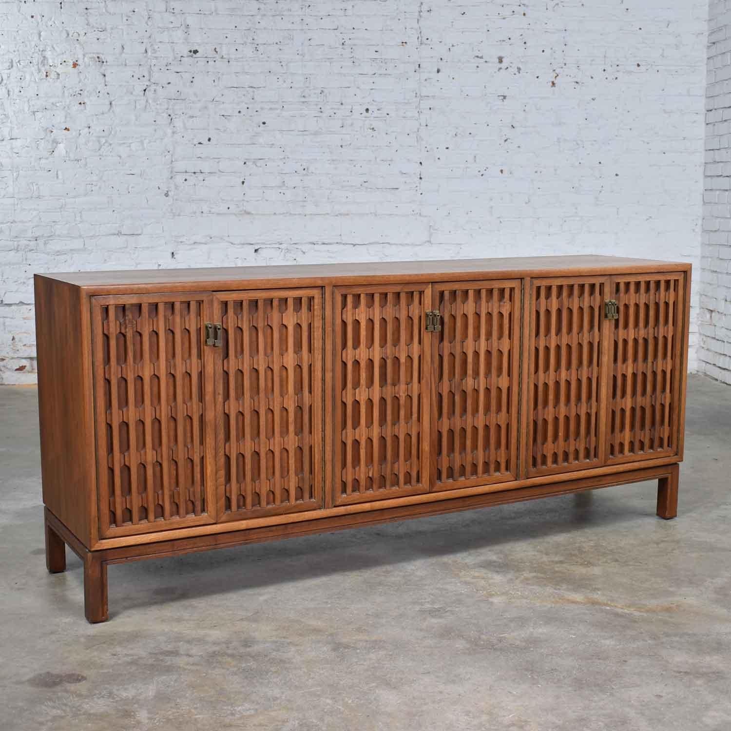 Handsome Mid-Century Modern walnut credenza unmarked but done in the style of John Stuart Widdicomb. It is in fabulous vintage condition. The top finish has been restored to remove some fading that had occurred. The rest of the piece retains its