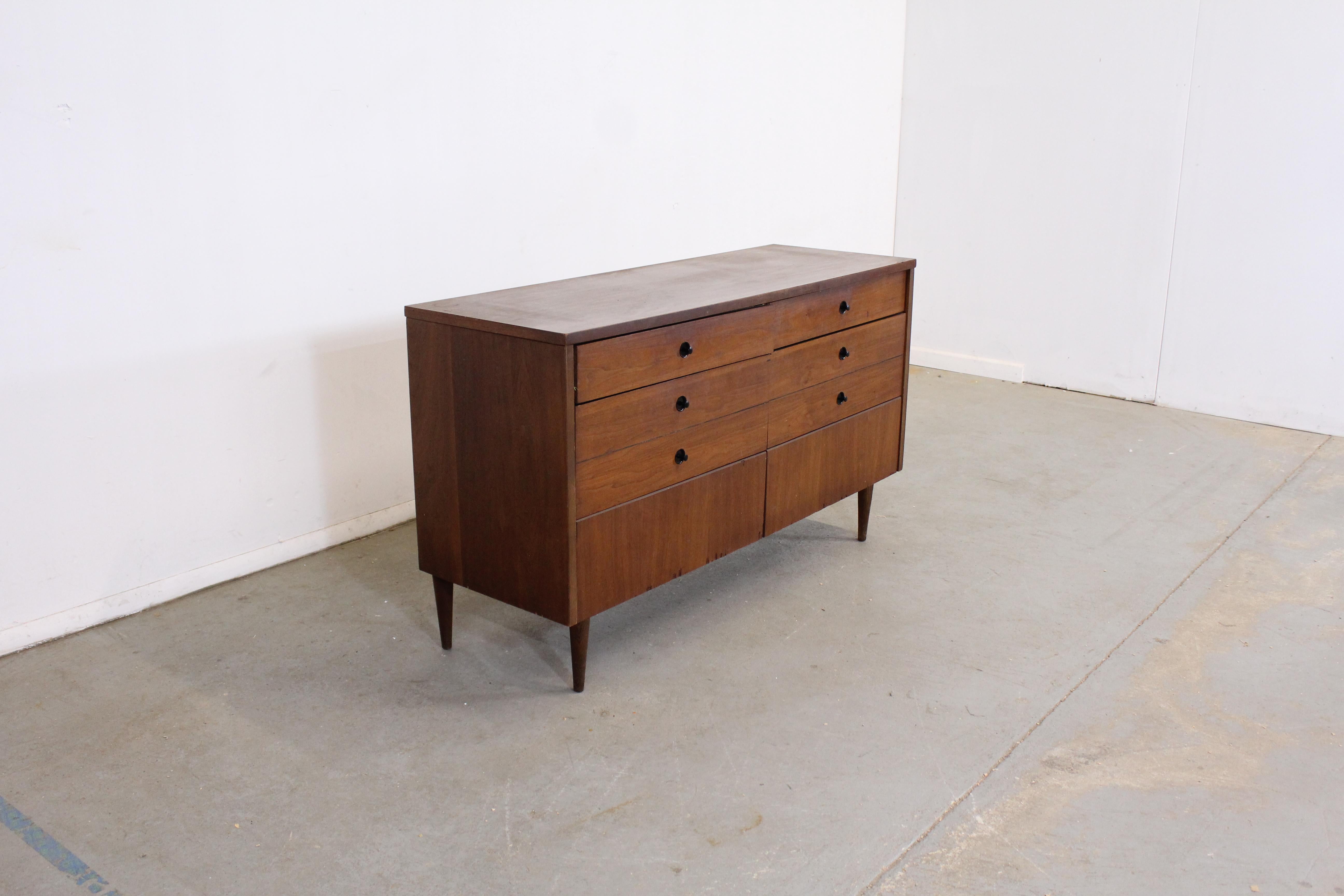 Mid-Century Modern walnut credenza on pencil legs

Offered is a vintage Mid-Century Modern credenza on pencil legs by Bassett Industries. Features a veneer top with 6 drawers with knobs. It is in overall good structural condition, has some small