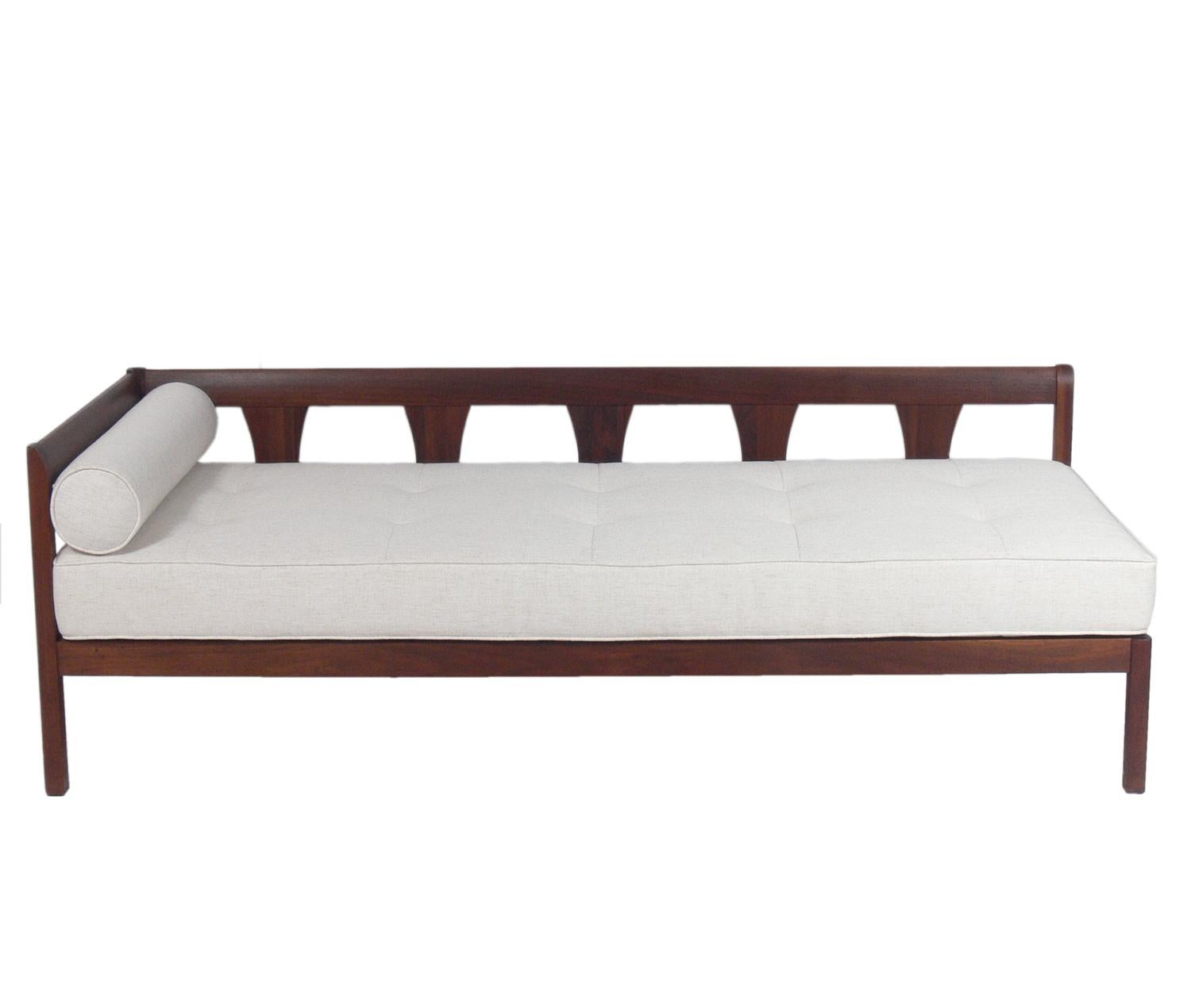 Mid-Century Modern walnut daybed, American, circa 1960s. This chaise lounge has a clean lined elegant design that would work well with Danish modern pieces. The walnut frame has been cleaned and Danish oiled. It has been reupholstered in an ivory