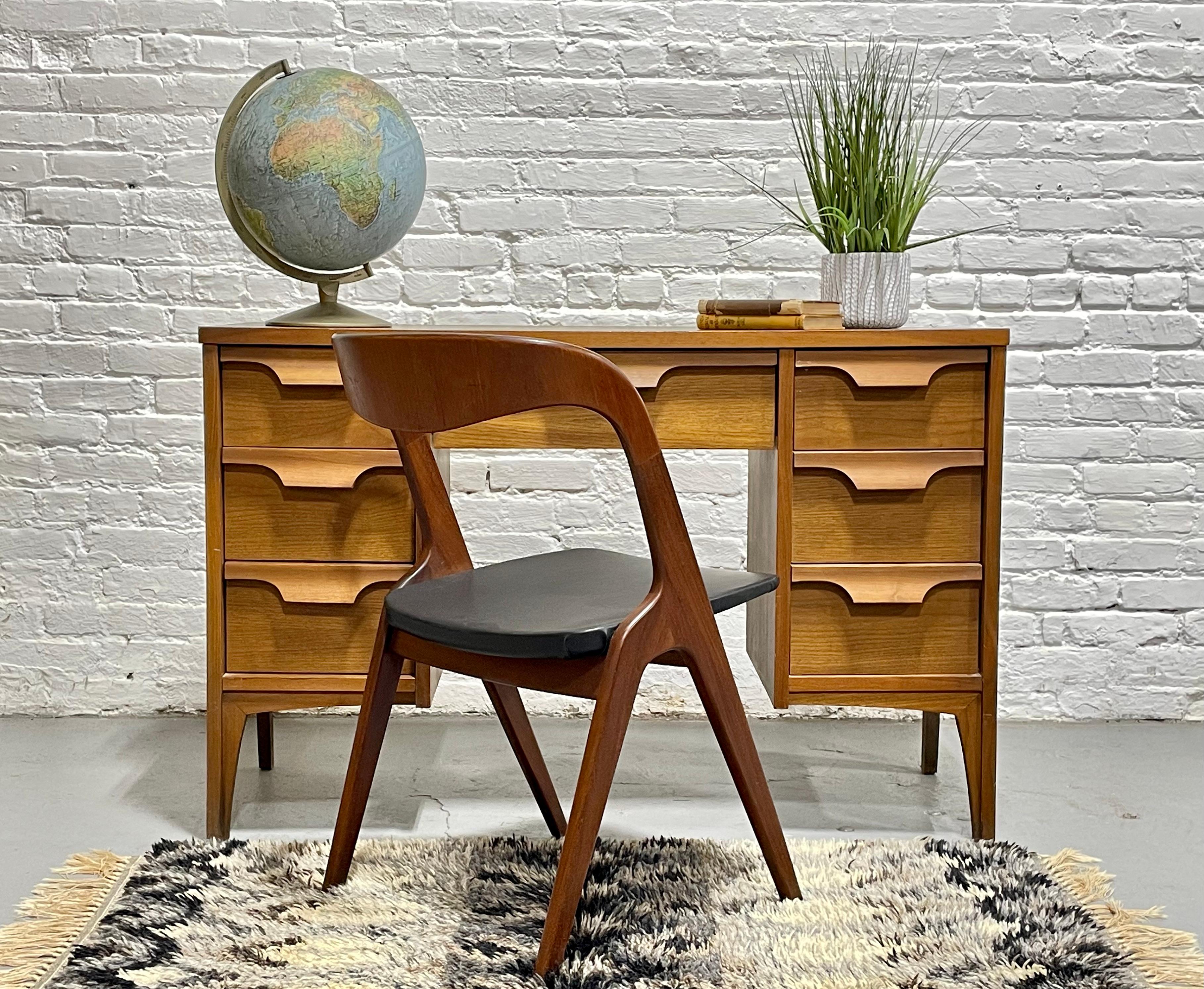 Mid Century Modern Walnut Desk by Johnson Carper, featuring chunky drawer pulls and seven deep and spacious drawers for plenty of storage space. The tabletop is a laminate (formica) woodgrain, perfect for withstanding the wear and tear of a work