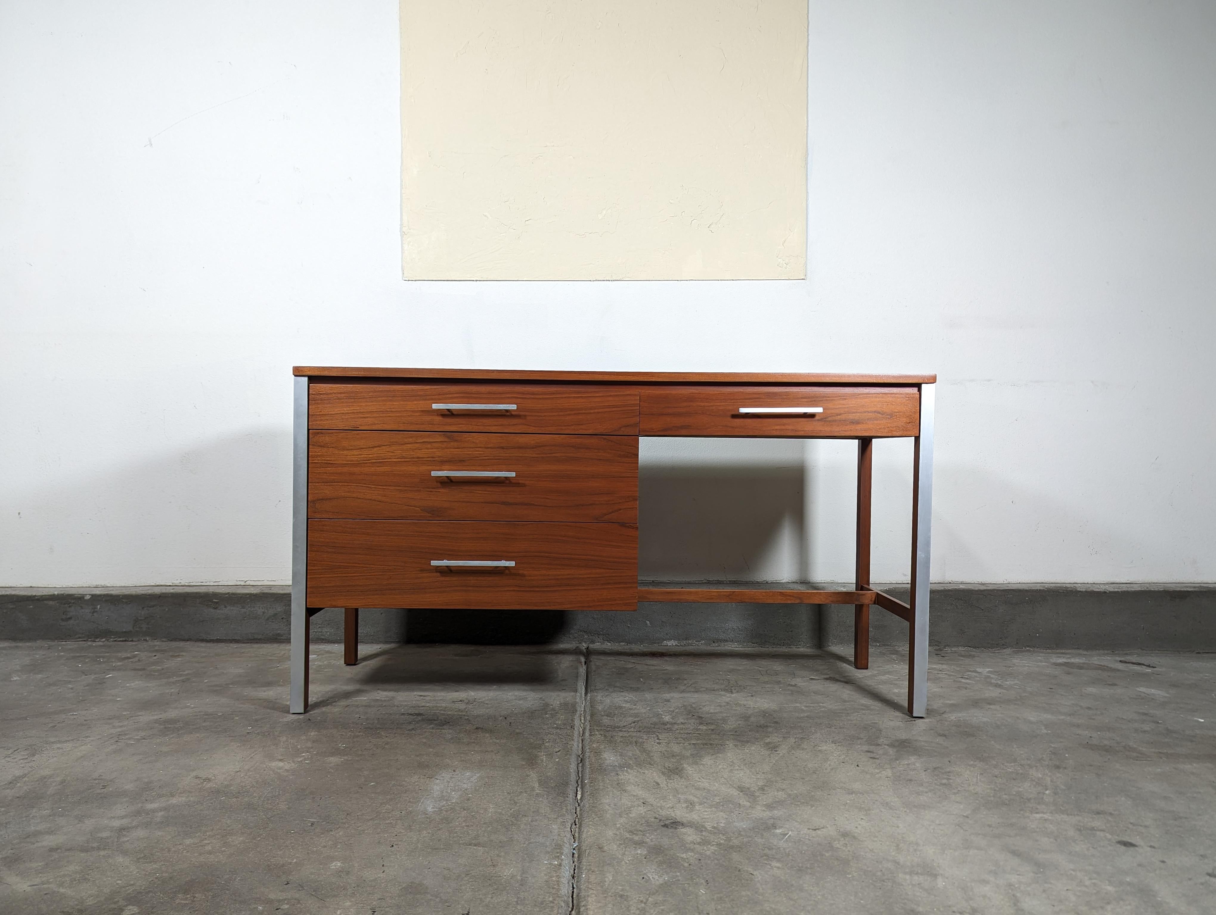 Step back in time with this show-stopping vintage mid century walnut desk, artfully designed by the renowned Paul McCobb. This piece is a quintessential representation of American mid century modern aesthetic - featuring clean lines, thoughtful
