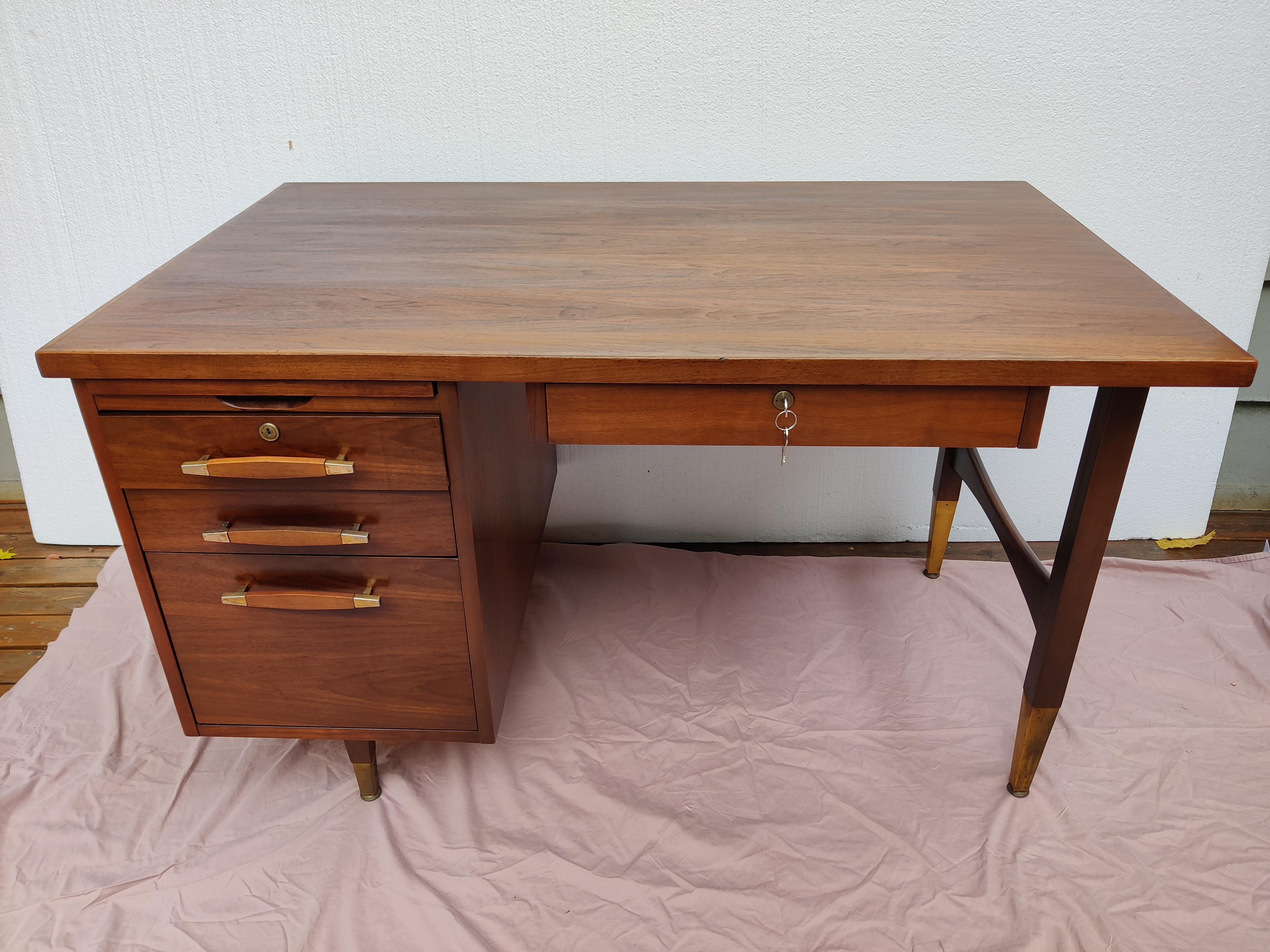Mid Century Modern Walnut Desk with brass and walnut pulls'
Brass caps on legs
Chair opening 28.25 W x 25 H (drawer bottom to floor).
2 locks with 2 keys each.
Touch up only on desk, original finish in good condition. 