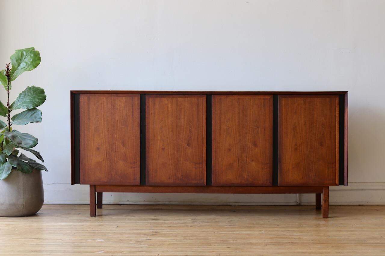 Mid-Century Modern dark walnut sideboard.
Made by Dillingham for the 'Esprit' collection.
Designed by Merton Gershun. 
Left side has three large dovetailed drawers with white fronts.
Right side holds a stationary shelf.
Gorgeous woodgrain