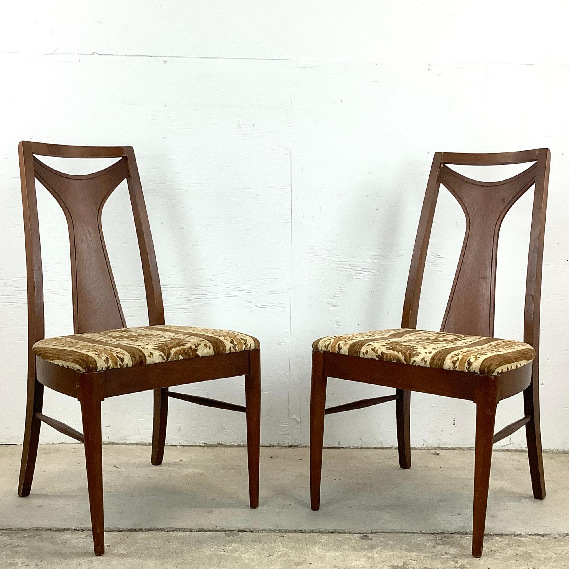 Genießen Sie die Verschmelzung von Form und Funktion mit diesem eleganten Paar Mid-Century Modern Dining Chairs. Diese Stühle, die jedes Esszimmer aufwerten, sind eine wahre Verbeugung vor der Raffinesse und dem innovativen Design der damaligen