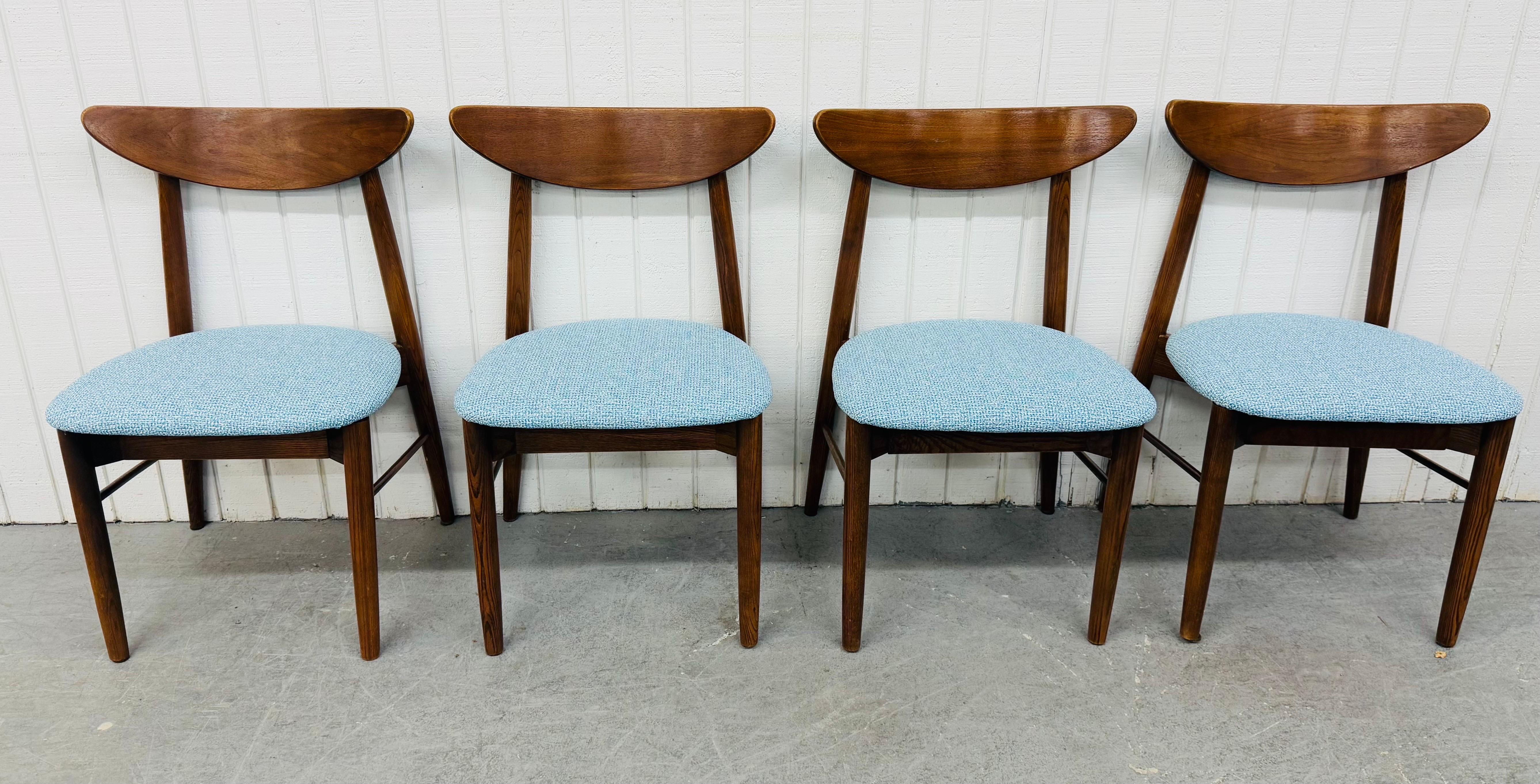 This listing is for a set of four Mid-Century Modern Walnut Dining Chairs. Featuring a curved back rest, solid wood frame, modern legs with stretcher base, newly upholstered blue seats, and a beautiful walnut finish. This is an exceptional