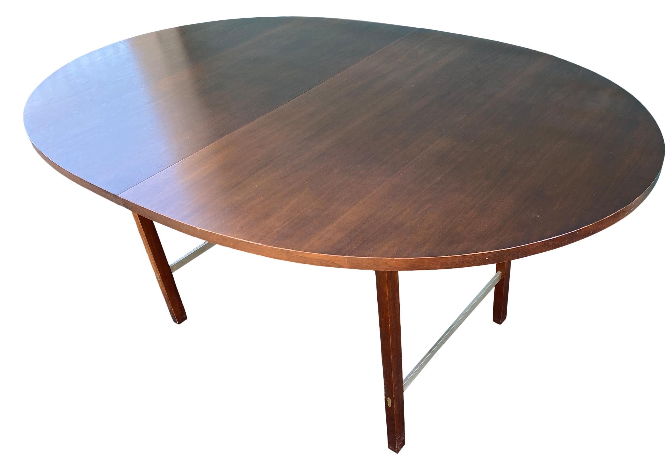 A Mid-Century Modern walnut extension dining table designed by Paul McCobb for Calvin Furniture. The table features dark walnut wood grain and aluminum stretchers. The table is in original vintage condition. Great Design.

Measures: 62