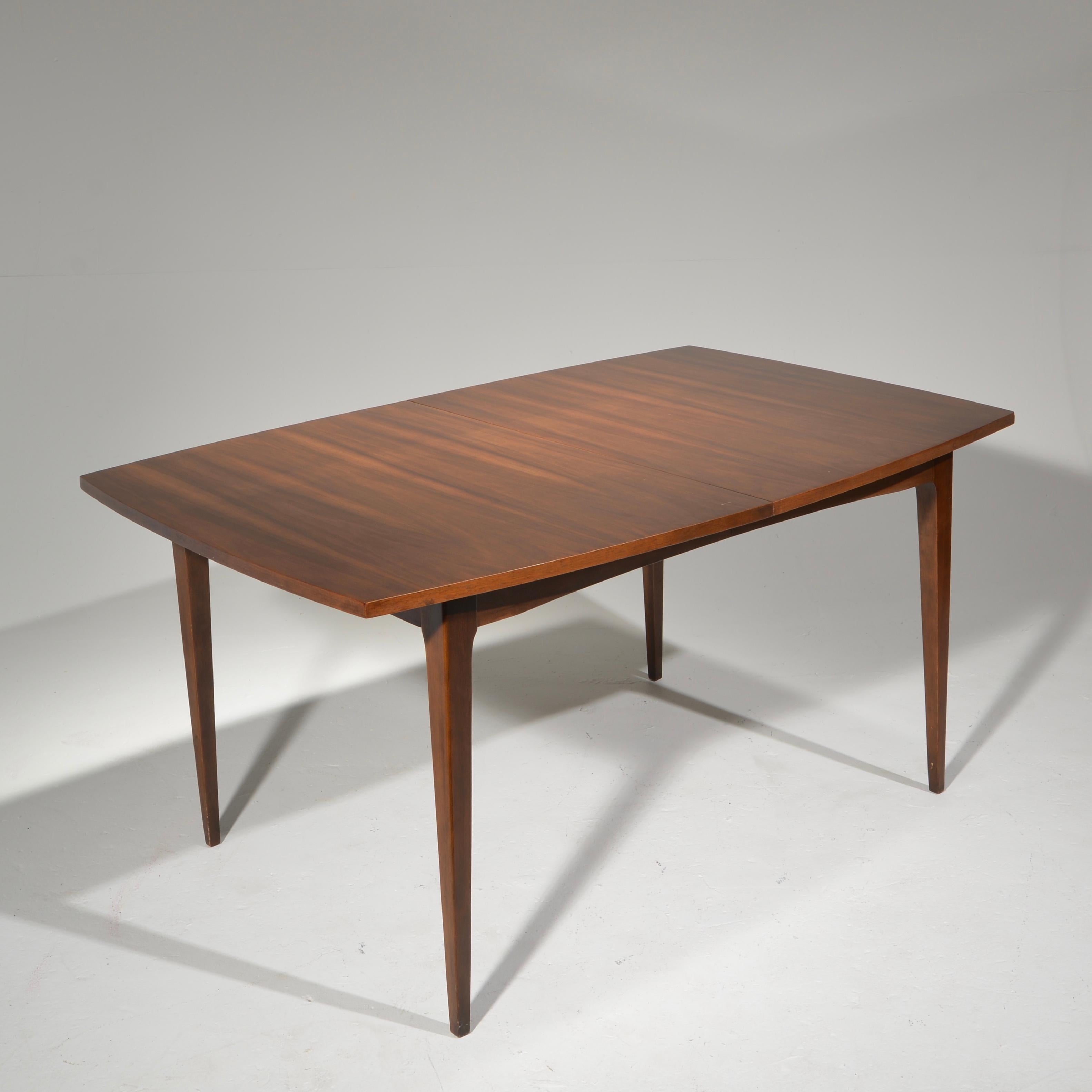 Beautiful midcentury walnut dining table that extends and collapses to fit your needs perfectly.