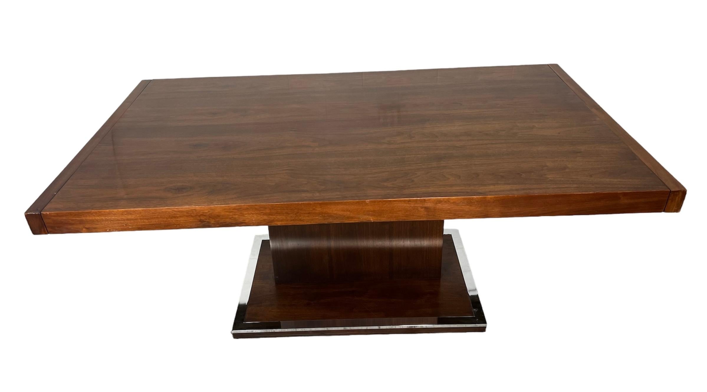 This is an extending walnut dining or conference table by Milo Baughman. With single pedestal leg. Made by Founders Furniture Company.
Very good vintage condition. Some light marks on the top. Some of the pegs that connect the leaves missing or