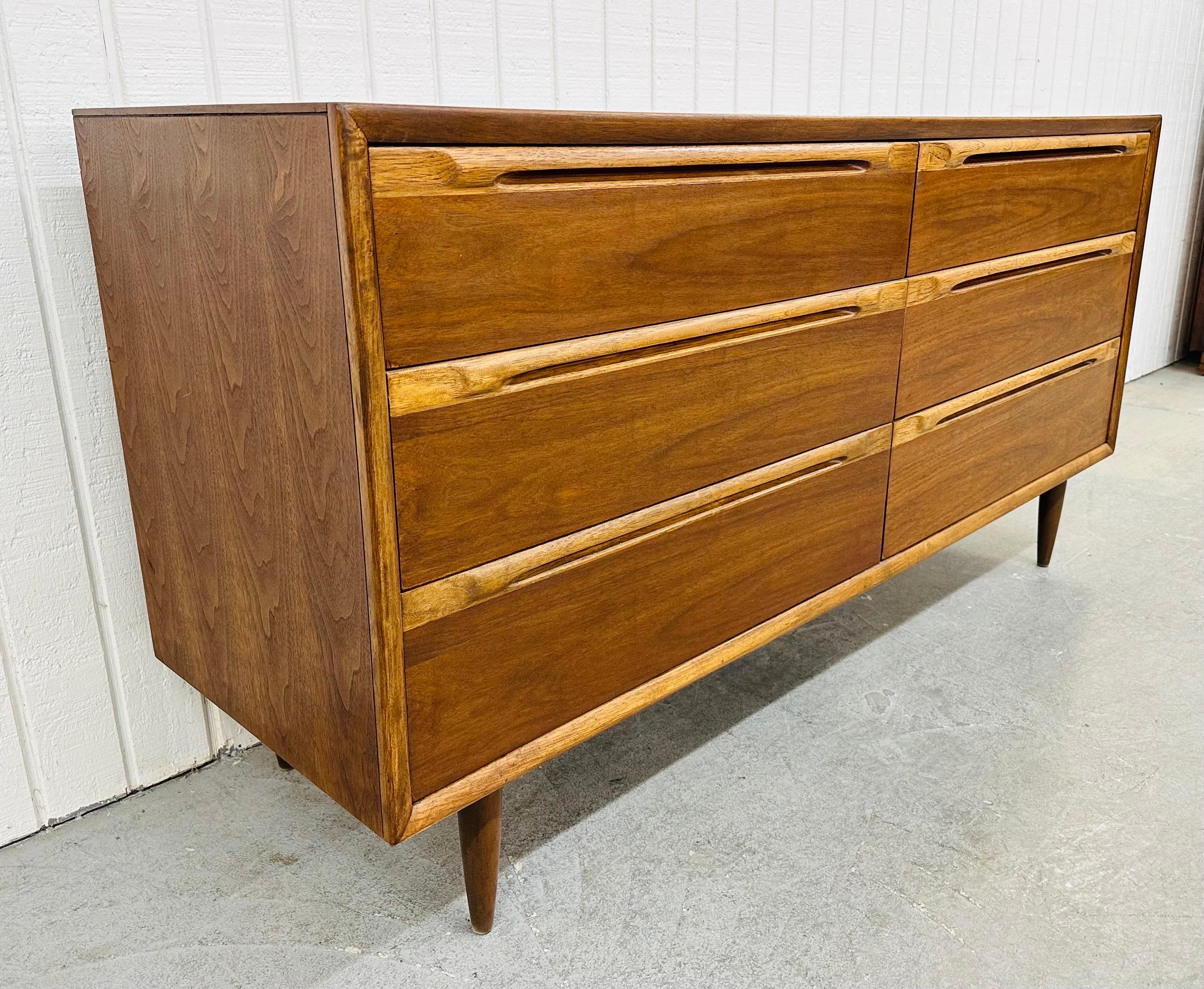 This listing is for a Mid-Century Modern Walnut Double Dresser. Featuring a straight line design, six large drawers for storage, recessed wooden pulls, modern legs, and a beautiful walnut finish! This is an exceptional combination of quality and