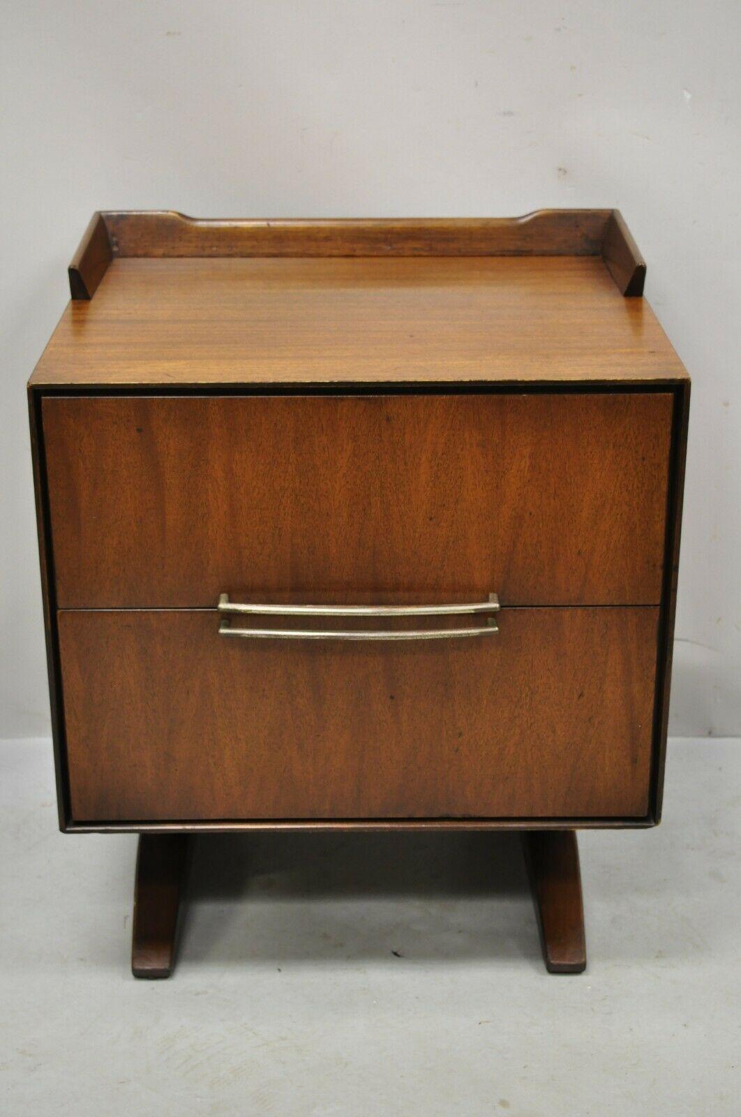 Mid-Century Modern walnut double pedestal nightstand bedside table. Item features sculpted metal pulls, double pedestal base, gallery top, 2 drawers, very nice vintage item, sleek sculptural form, nice larger size. Circa Mid 20th Century.