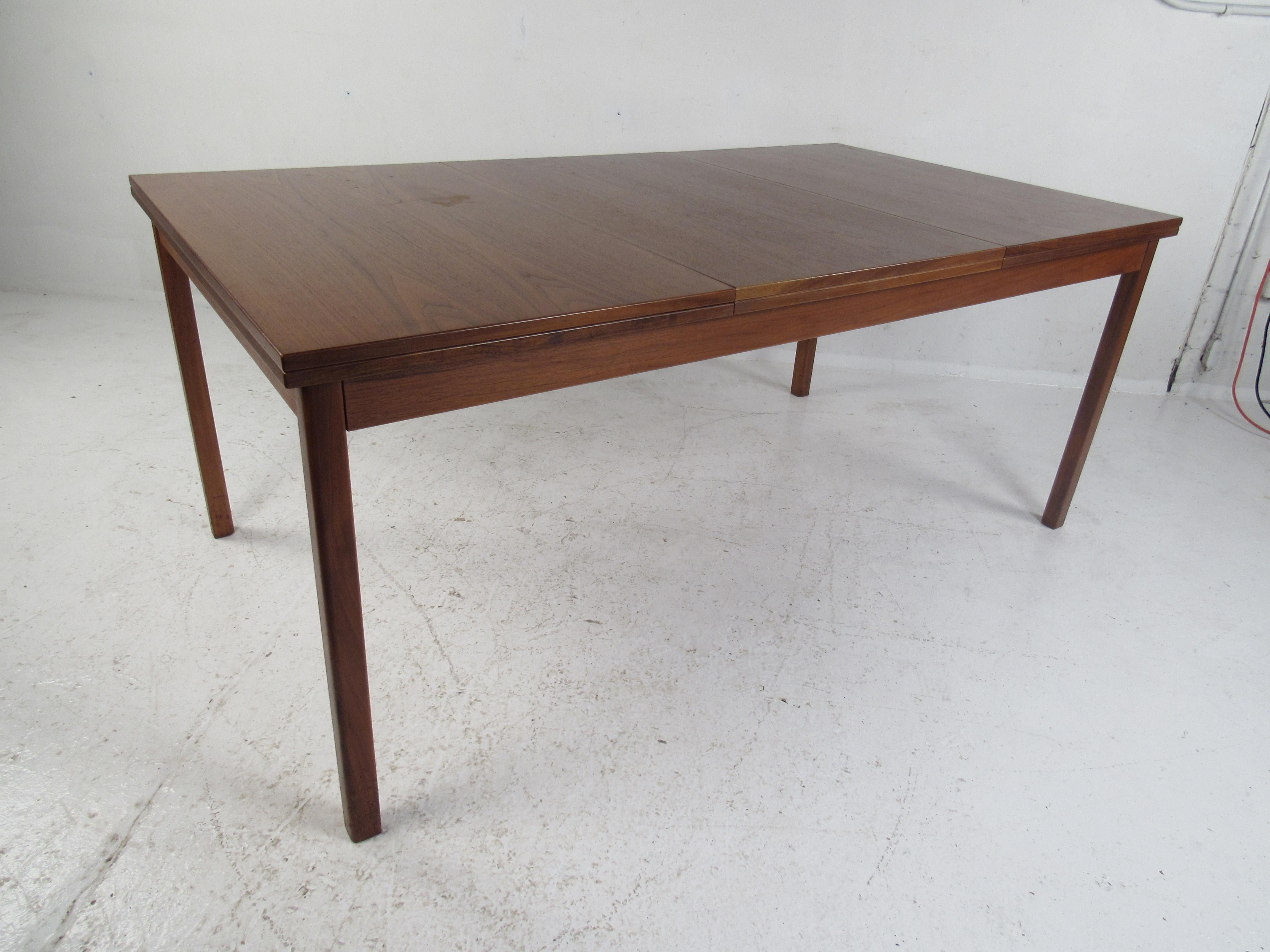 A unique draw leaf design with the ability to cater to many guests. This impressive vintage modern table has four leaves that draw out and extend this table to 118.5 inches wide. A charming vintage walnut finish adds to the midcentury appeal. Please