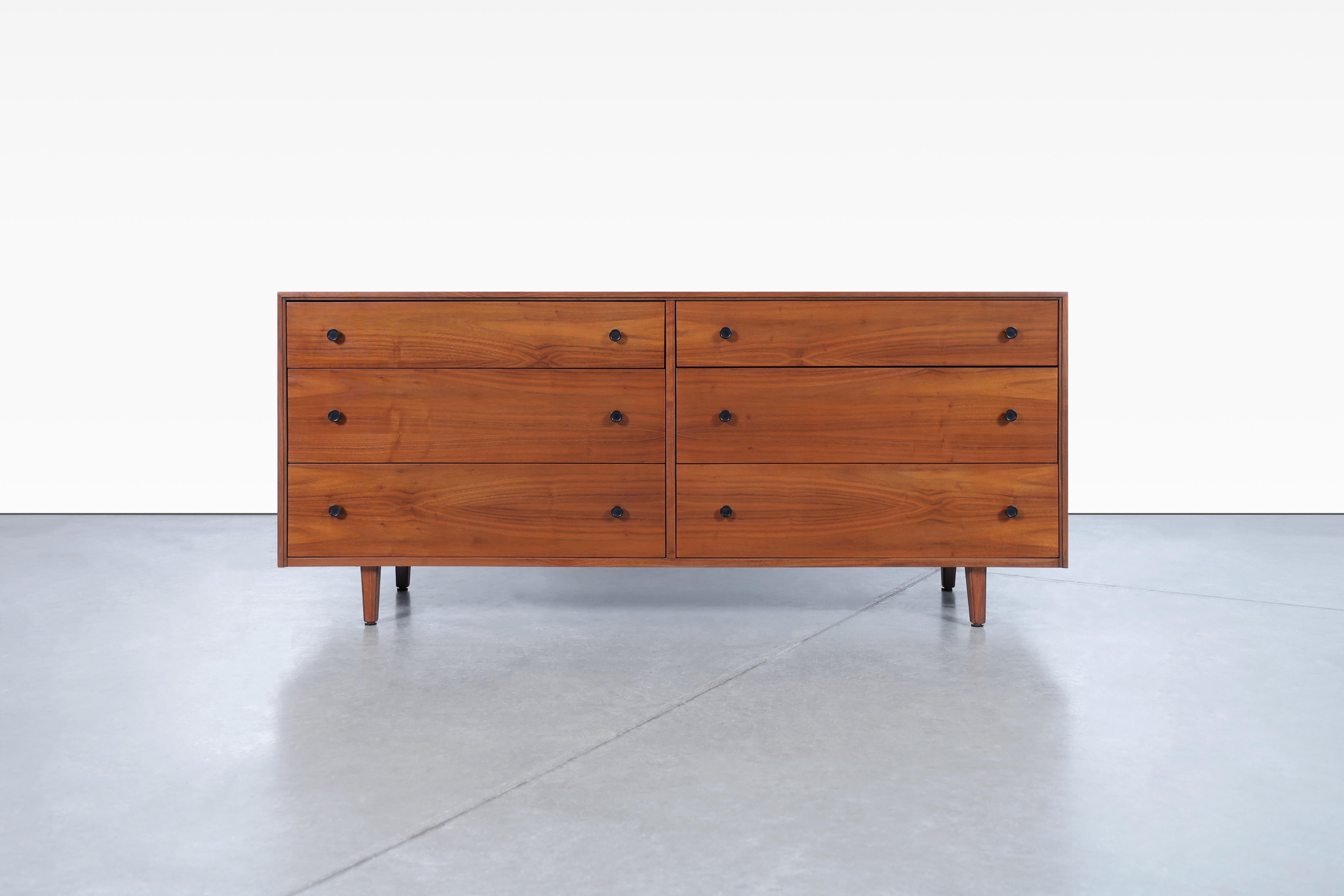 Beautiful mid-century modern walnut chest of drawers attributed to Kipp Steward for Glenn of California, designed in the United States, circa 1960's. This stunning piece has been professionally restored, giving it an exquisite vintage look that is