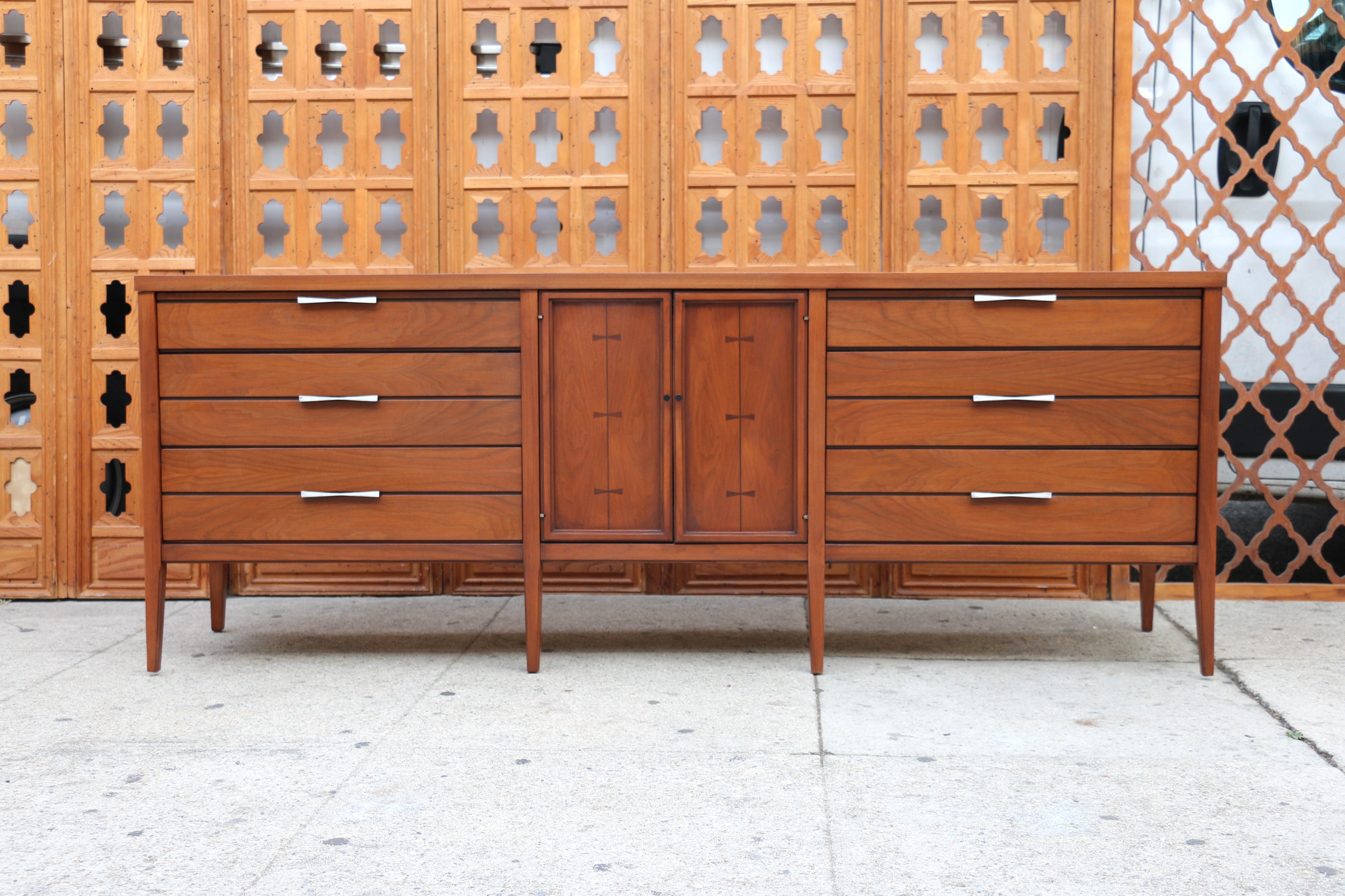 Wonderful Mid-Century Modern Dresser designed by Lane, ( it has the label in the drawers). Originally from the 1960’s. Featuring a straight line design, three drawers on each side with original metal handles, center doors that open up to three