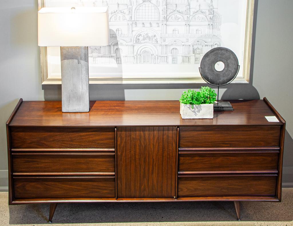 Introducing the ultimate statement piece for any Mid-Century Modern enthusiast. This stunning piece, made in the USA circa 1960's, showcases the timeless beauty and craftsmanship of the era. Made from the finest walnut woods, this dresser has been