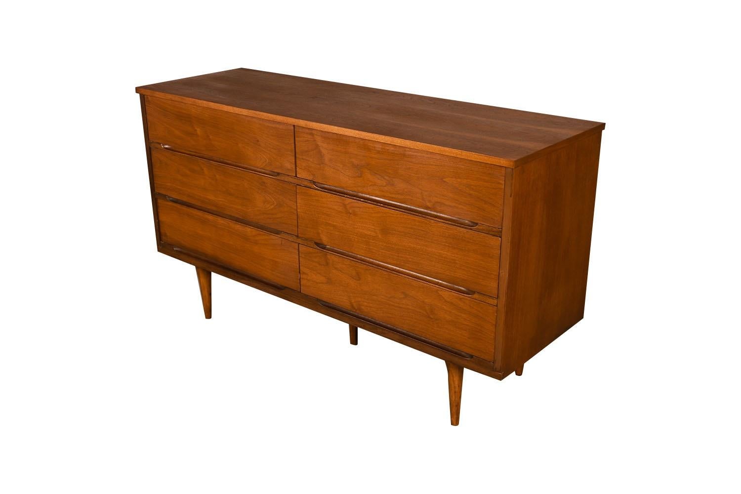 Attractive long mid-century modern sleek smooth face 6 drawer dresser. This is a very simple yet modern 6 drawer design. Each drawer has beautiful medium tone stunning walnut grains with minimal inset pulls. At the pull of the 6 drawers, you will