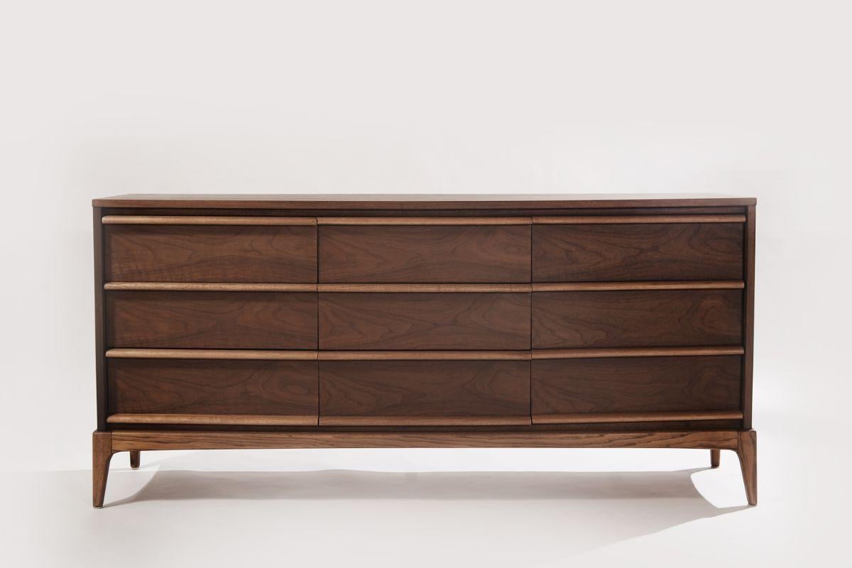 A walnut dresser originally from the 1950s. Completely restored to its original integrity in our organic water and scratch-resistant finish.
Featuring a walnut case and drawer fronts but contrasted by the natural oak pulls and base.

Designers