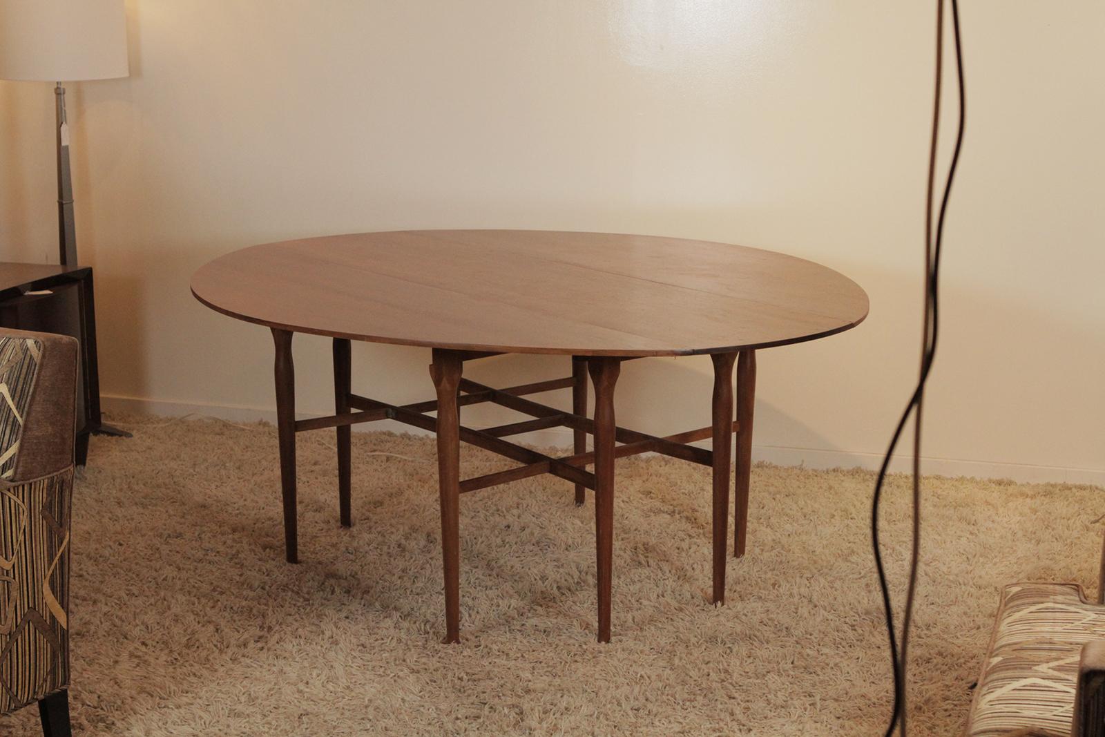A classic sleek walnut drop-leaf table with two drop leaves. Measures: The table with leaves down, 72 long, 19.5 deep leaves up 72 by 60. 29 inches tall.