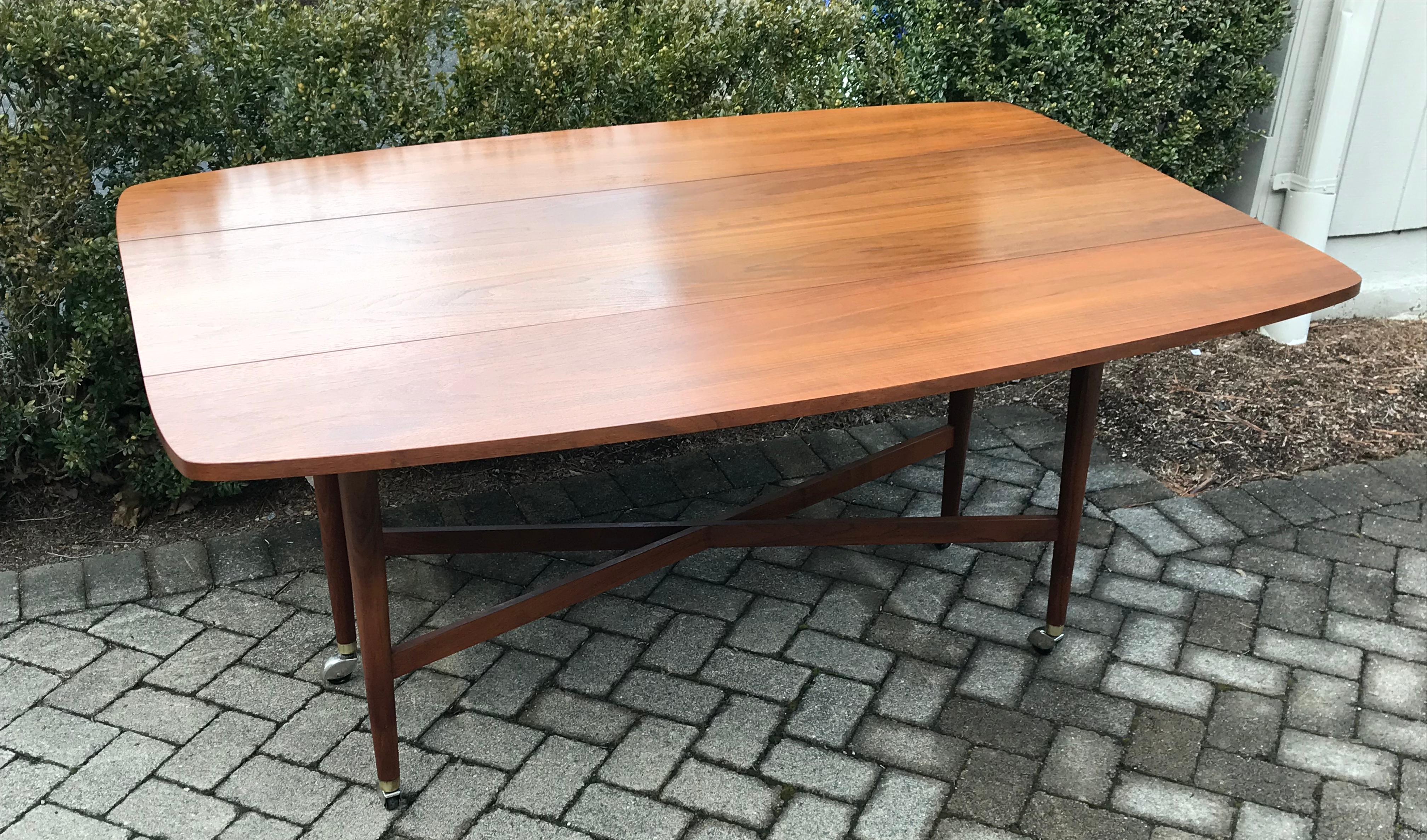 Beautiful midcentury walnut drop leaf dining table by Drexel. Part of the Declaration series, it has clean rounded corners, X-base leg detail and original castors. Very solid and well constructed. Great condition, very minor paint slivers in grain