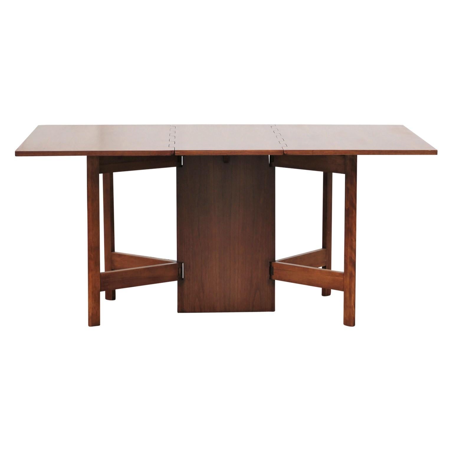 Sculptural drop-leaf dining table with gate leg. The table was designed by George Nelson for Herman Miller and is made from walnut.
 