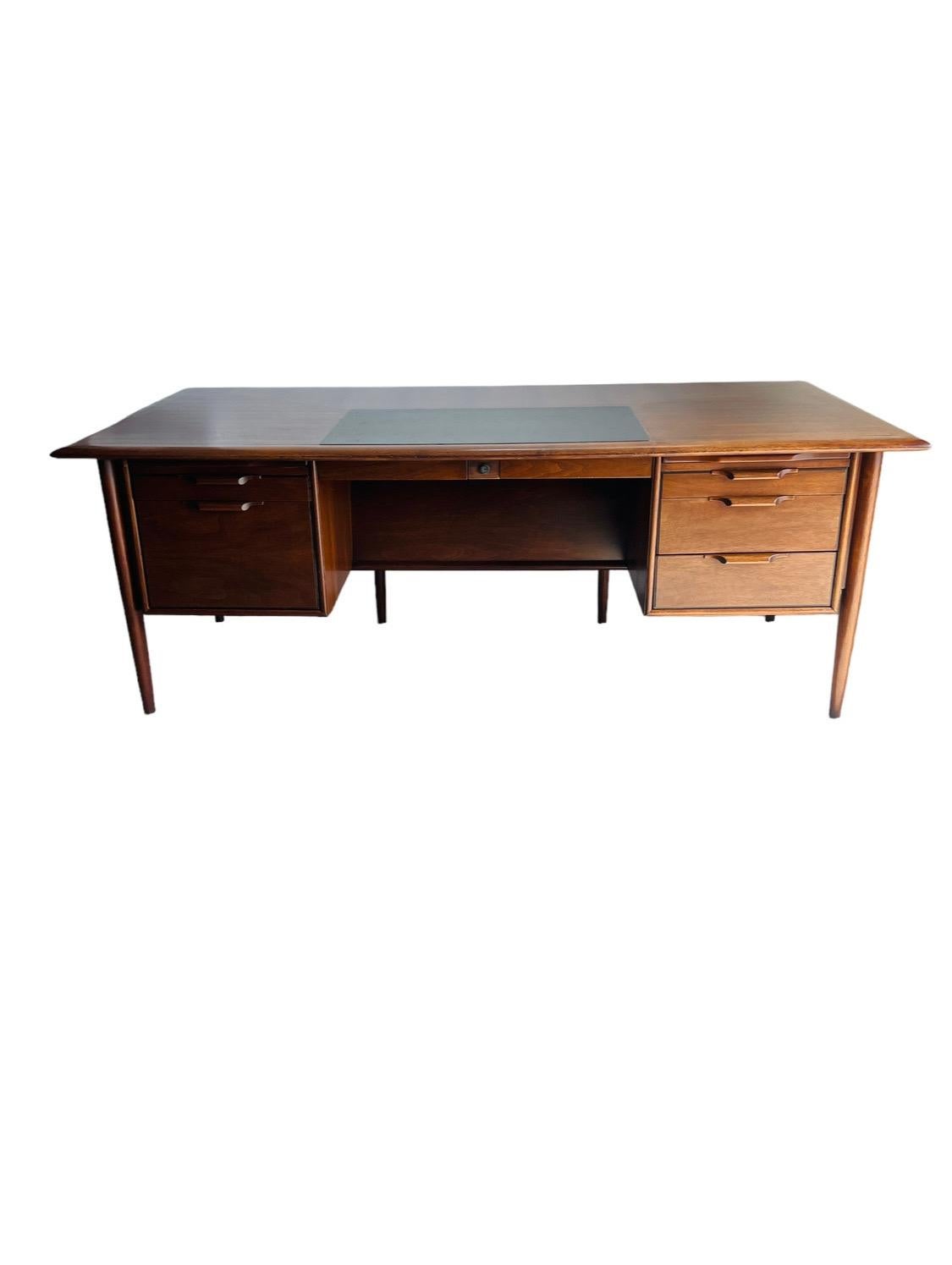 Introducing the Castillian Alma Executive Desk - a pinnacle of mid-century modern design that combines functionality with understated elegance. Crafted from rich walnut, this desk offers a robust workspace, measuring 78 inches in width, 38 inches in