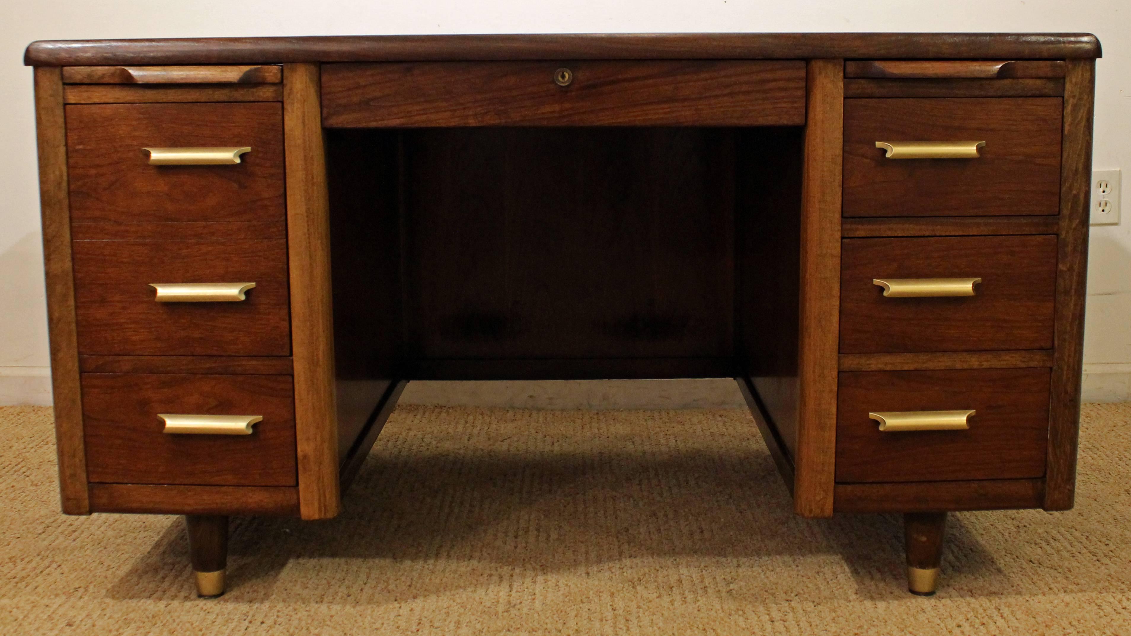 This is a walnut desk that features six dovetailed drawers and two pull-out leaves. It has a lock on the middle drawer, but we do not have the key. Has been completely restored/refinished.