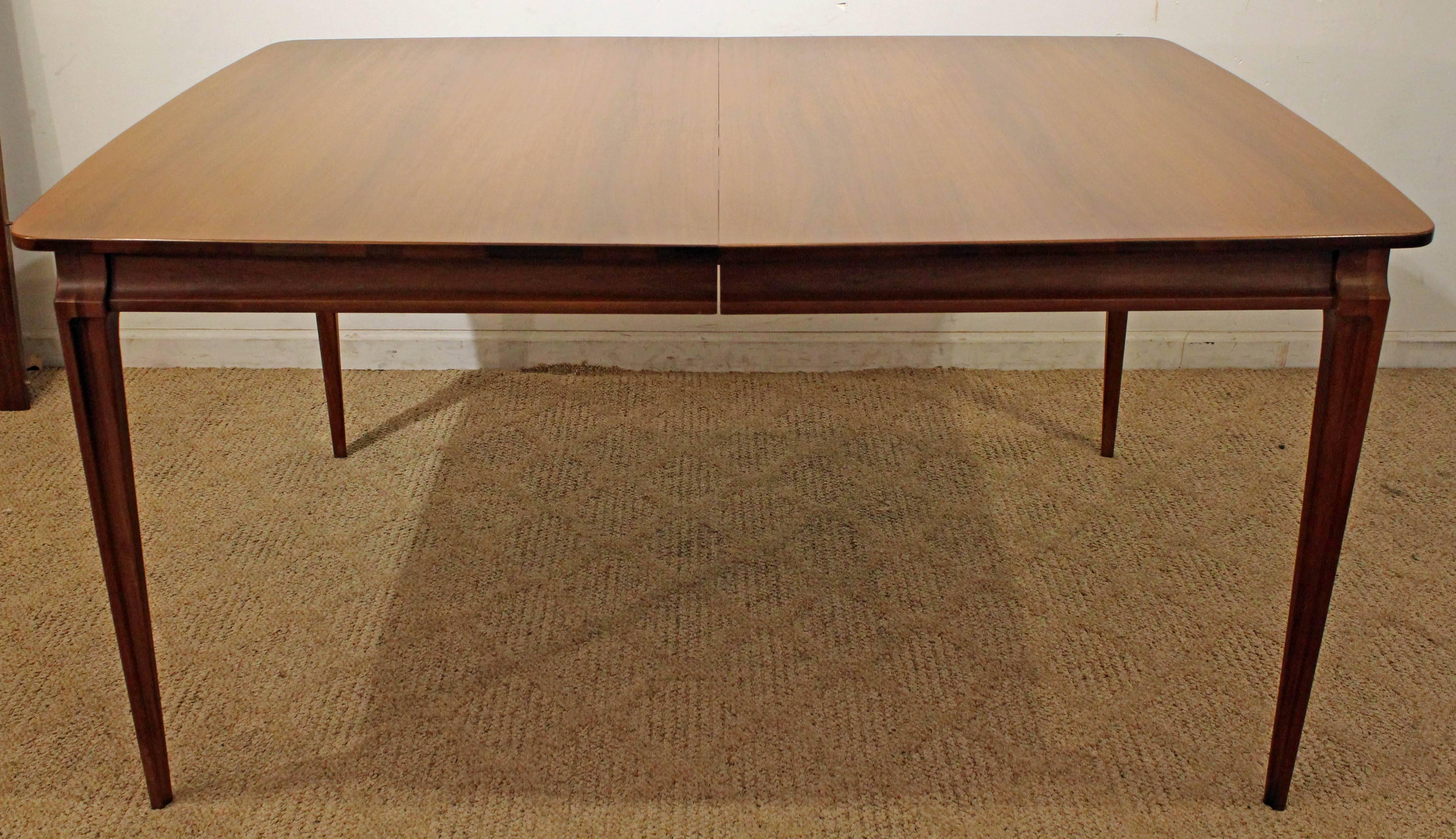 Offered is a Mid-Century Modern dining table. It is made of walnut and includes two extension boards. It is in good condition for its age, shows some age wear (sun fade, surface scratches, age wear-see pictures). It is not branded. A great set to