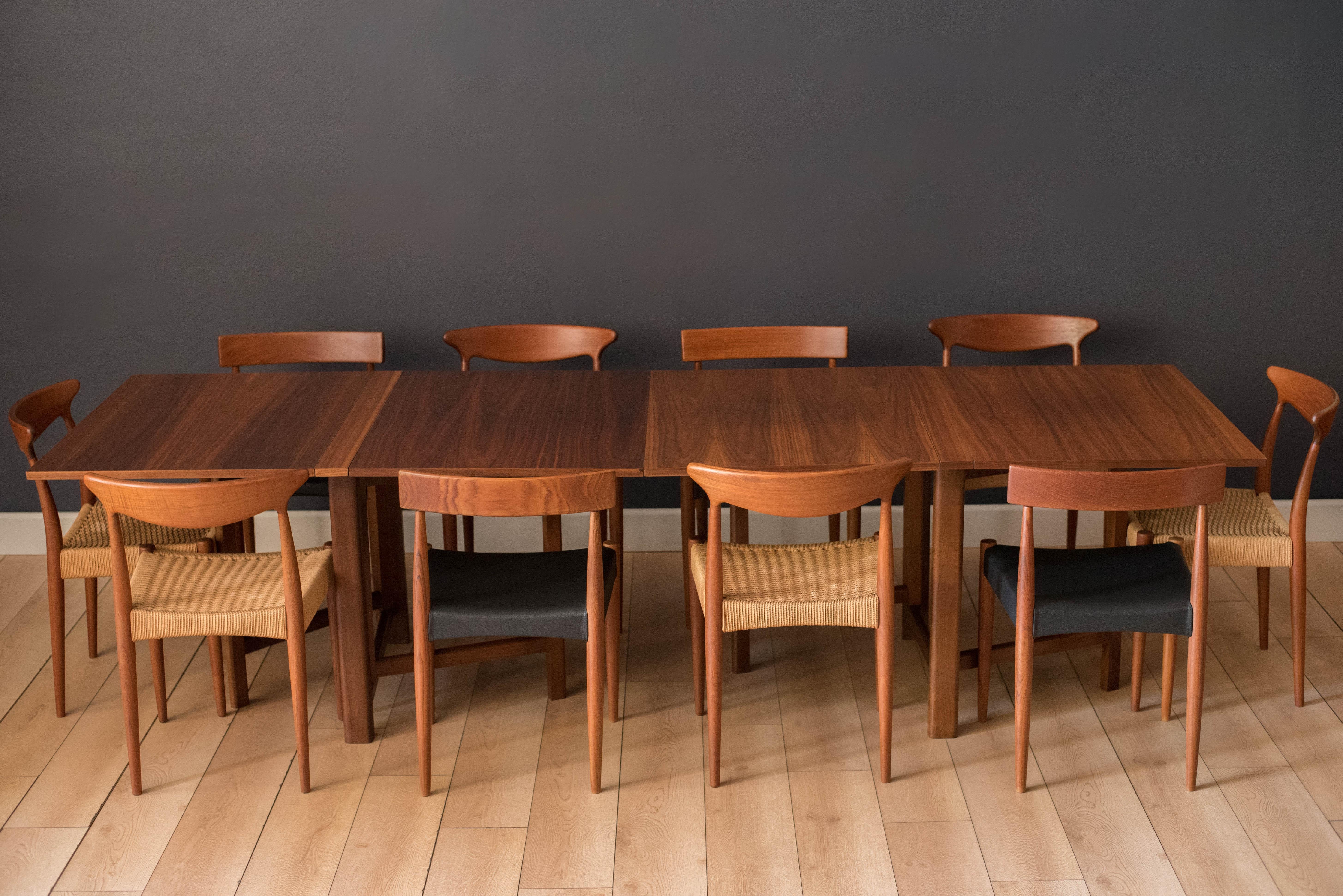 Vintage expandable rectangular shaped dining table in walnut, circa 1960s. This clever design includes a drop leaf extension feature with a foldable gate leg base making this a versatile piece for many occasions. Seats up to 2-10 guests. 

Table