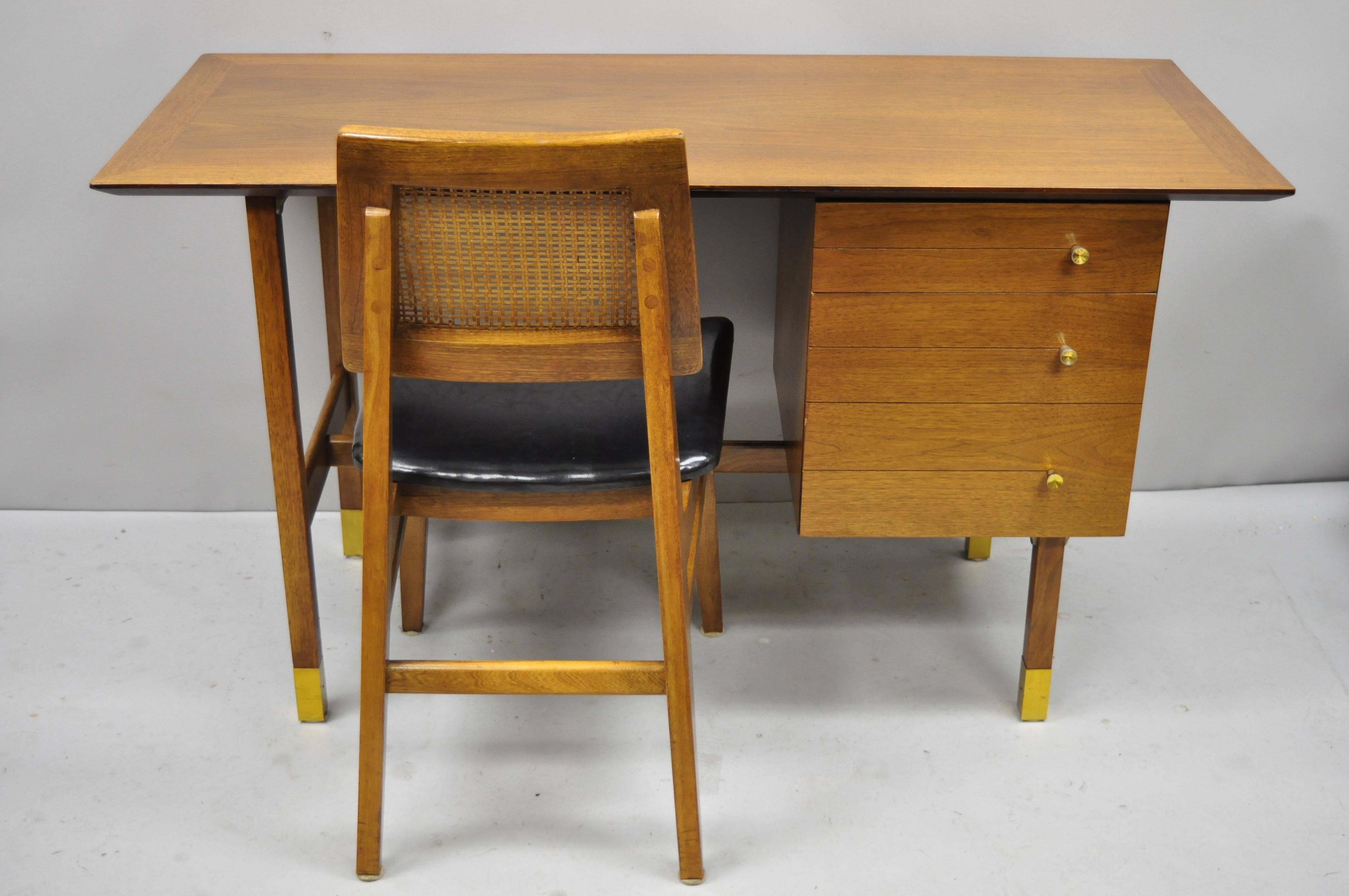 Mid-Century Modern walnut floating top writing desk and cane Hibriten desk chair. Item features floating form writing desk with brass feet, sleek vintage desk chair with cane back, (Hibriten chair Co.) label to chair, beautiful wood grain, finished