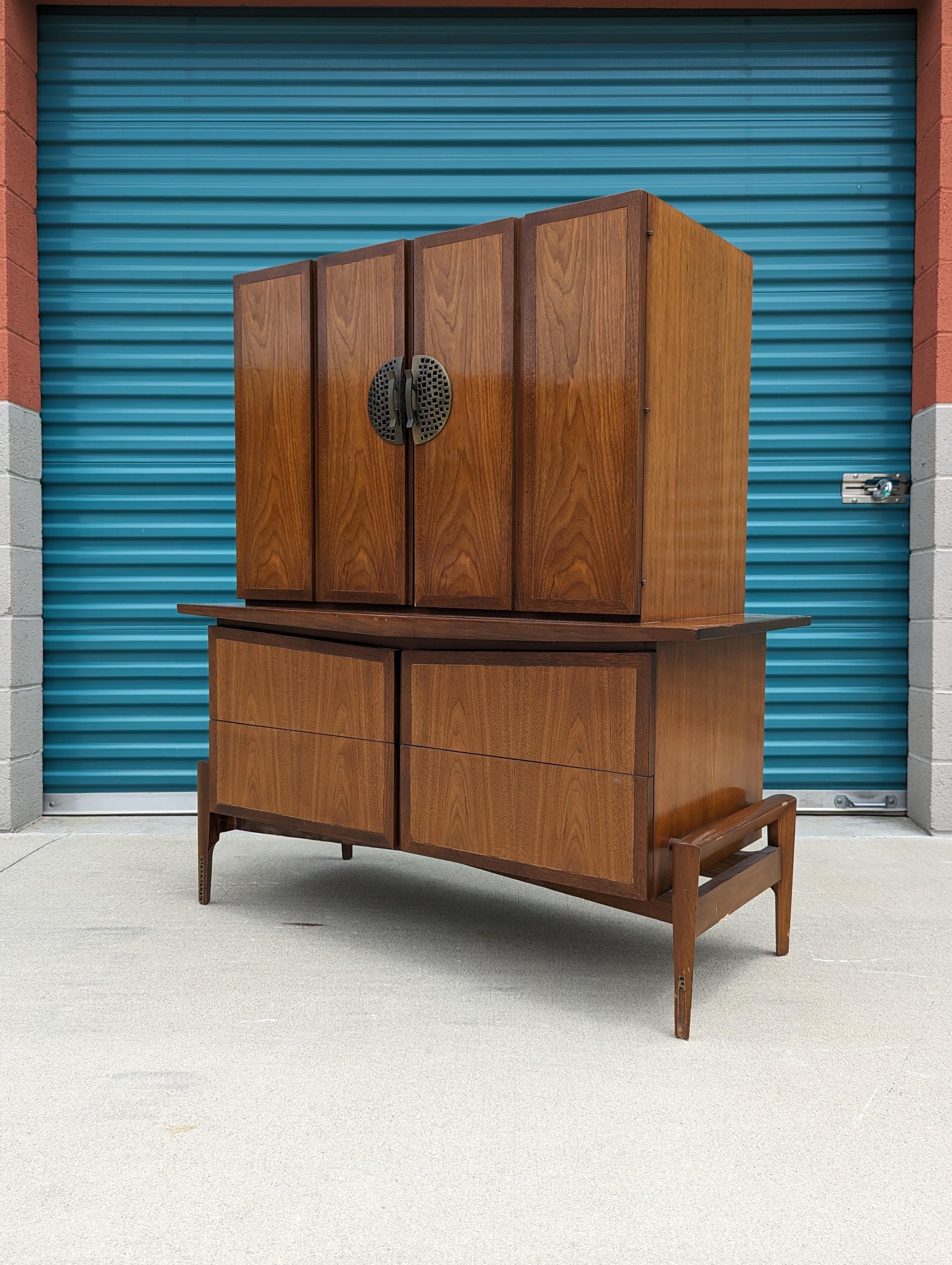 Just in, a walnut and bronze highboy/gentleman's chest by Helen Hobey Baker, c1960s. This piece is in original condition and features a walnut finish with a skeletal base making it almost seem like it's suspended in air. Two doors on the upper