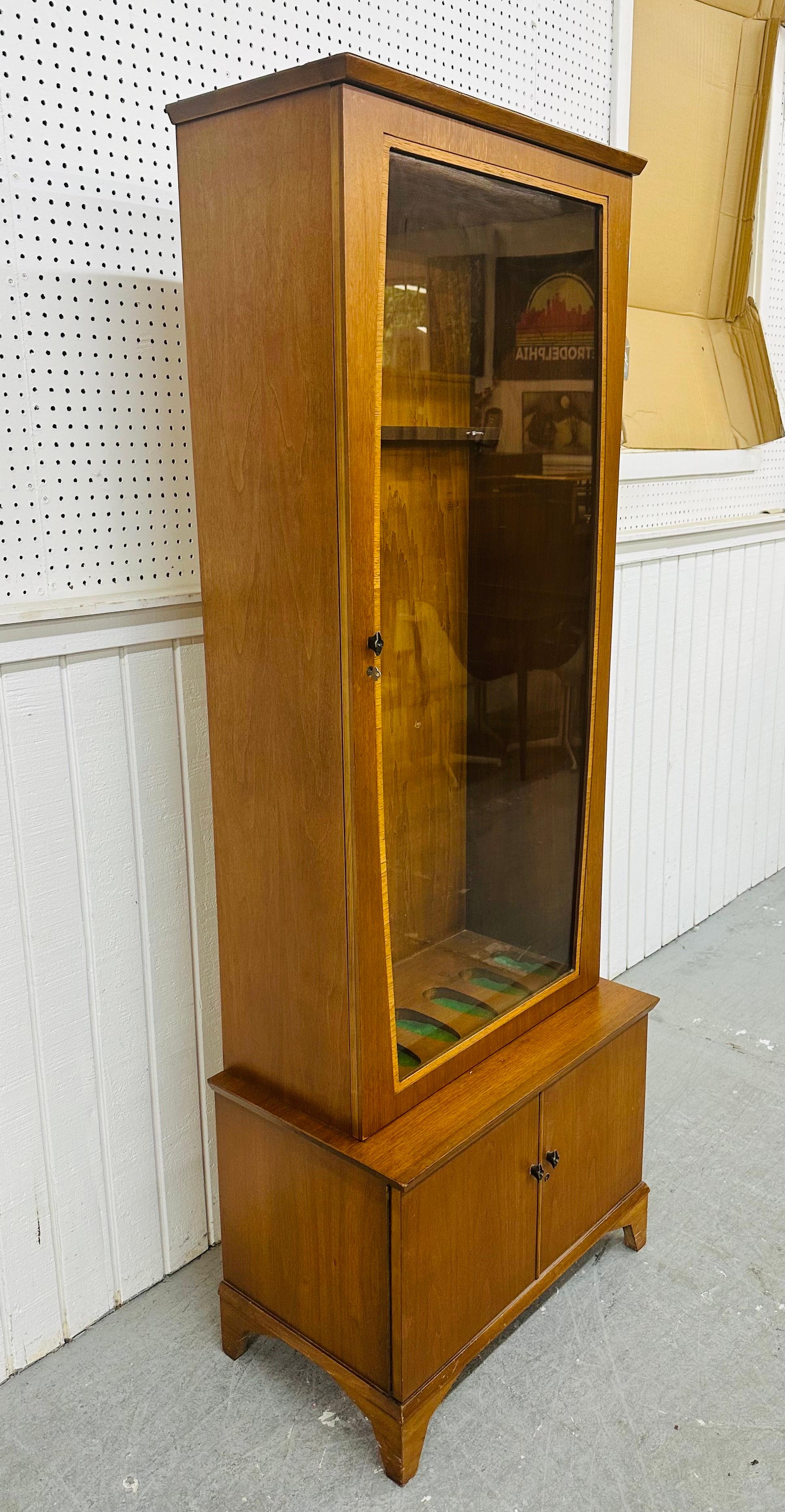 This listing is for a Mid-Century Modern Walnut Gun Cabinet. Featuring a straight line design, glass display door that opens up to storage, two doors at the bottom at open up to more storage space, modern legs, and a beautiful walnut finish. This is