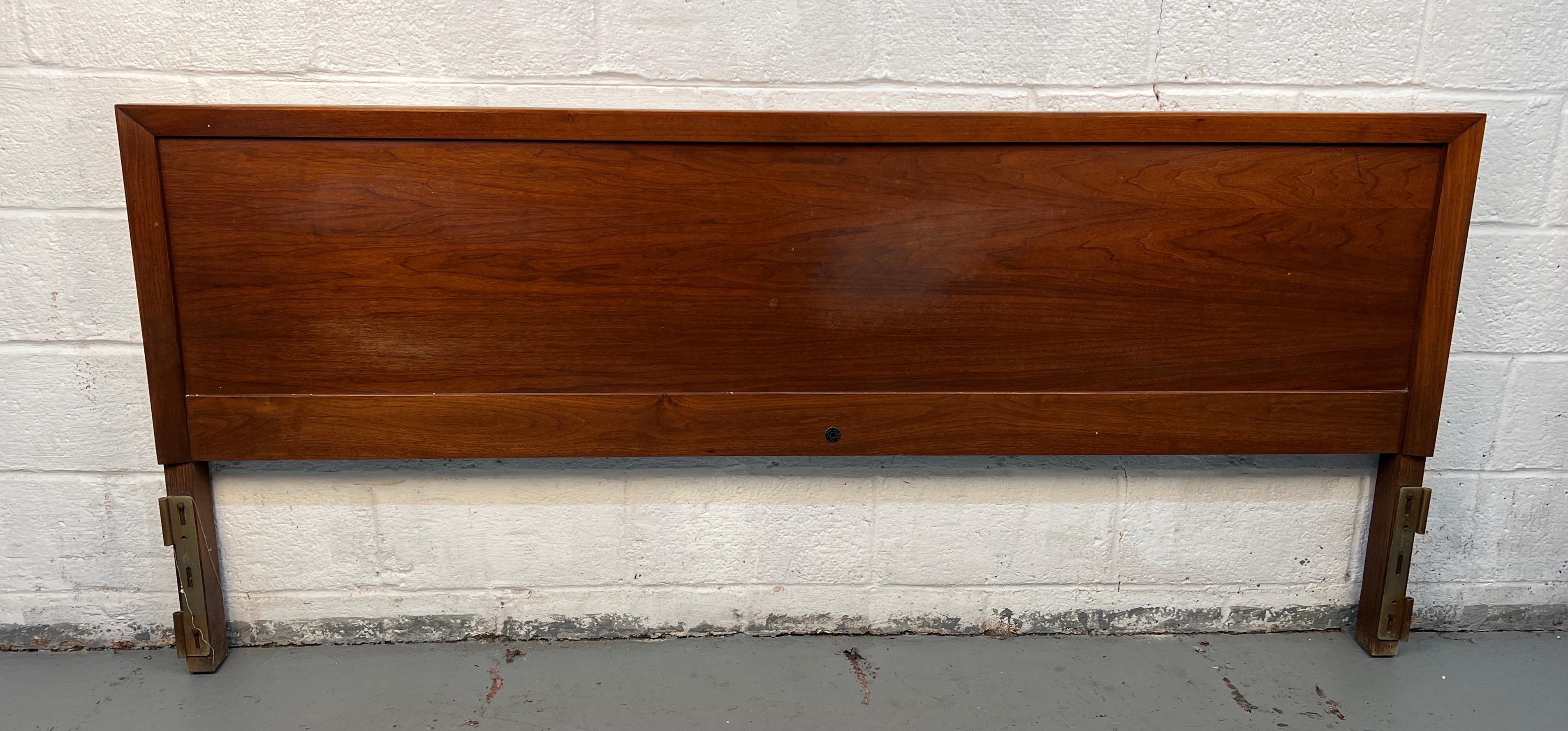 Elegante testiera in legno di noce della metà del secolo scorso disegnata da John Stuart. Grazie alla maestria artigianale del marchio, presenta linee pulite, splendide venature di noce e un fascino moderno e senza tempo: un pezzo eccezionale per