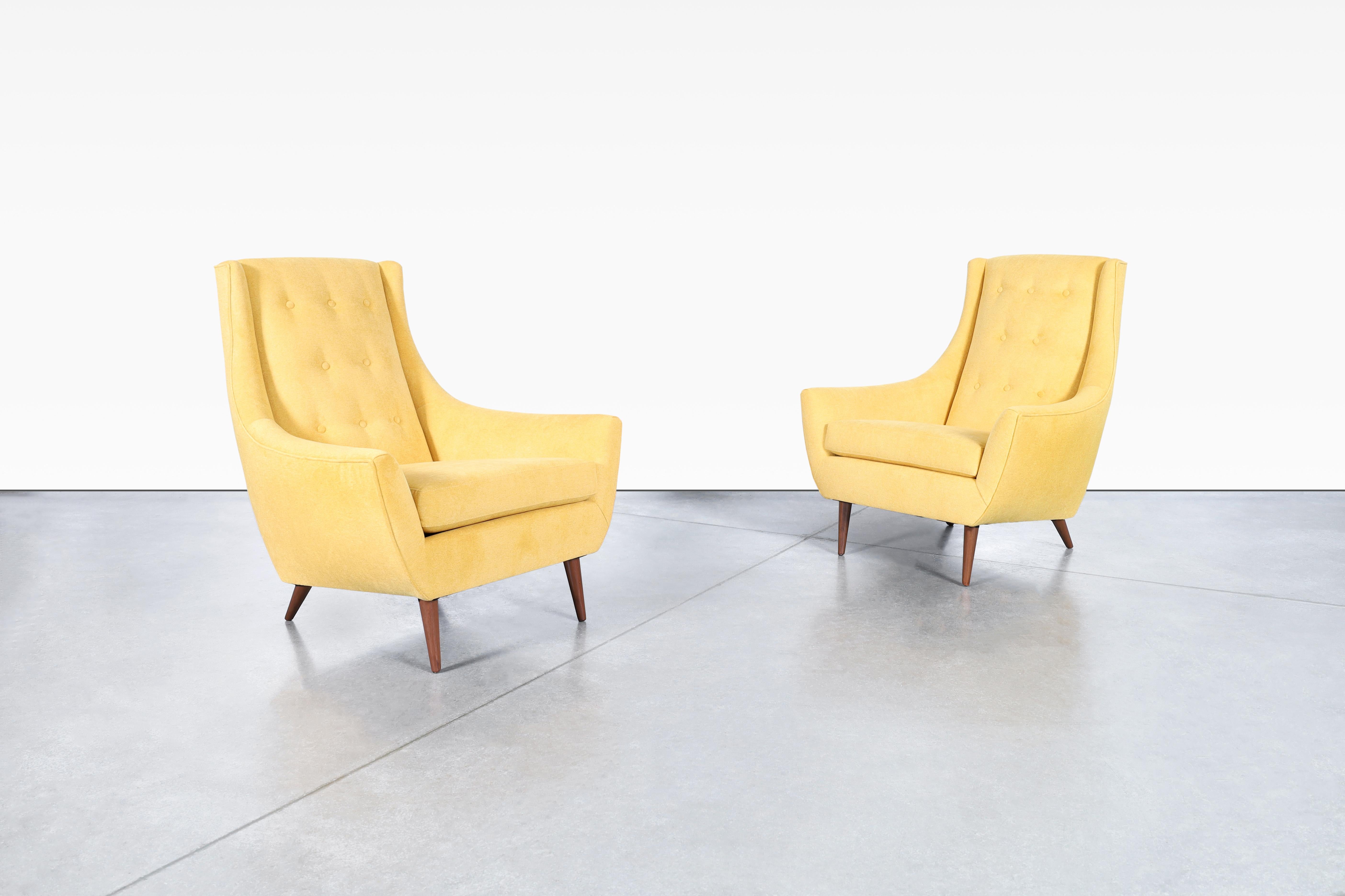 These mid-century modern lounge chairs are a true gem from the 1960s in the United States. The chairs have been refinished and reupholstered to bring them back to their full glory. The curvature design of the chairs, combined with their solid walnut