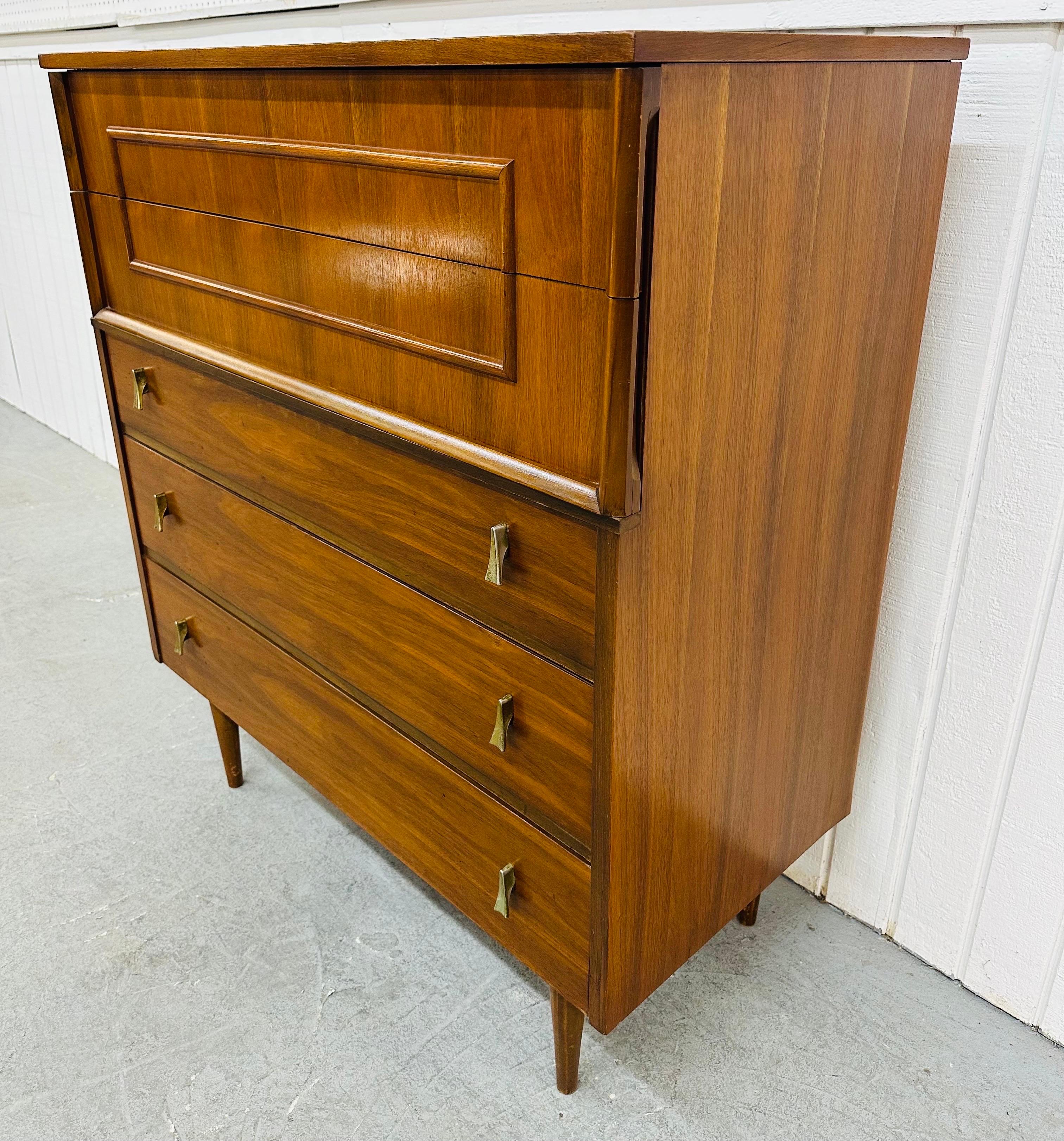This listing is for a Mid-Century Modern Walnut High Chest. Featuring a straight line design, two drawers at the top with wooden pulls, three drawers at the bottom with original brass hardware, modern legs, and a beautiful walnut finish. This is an