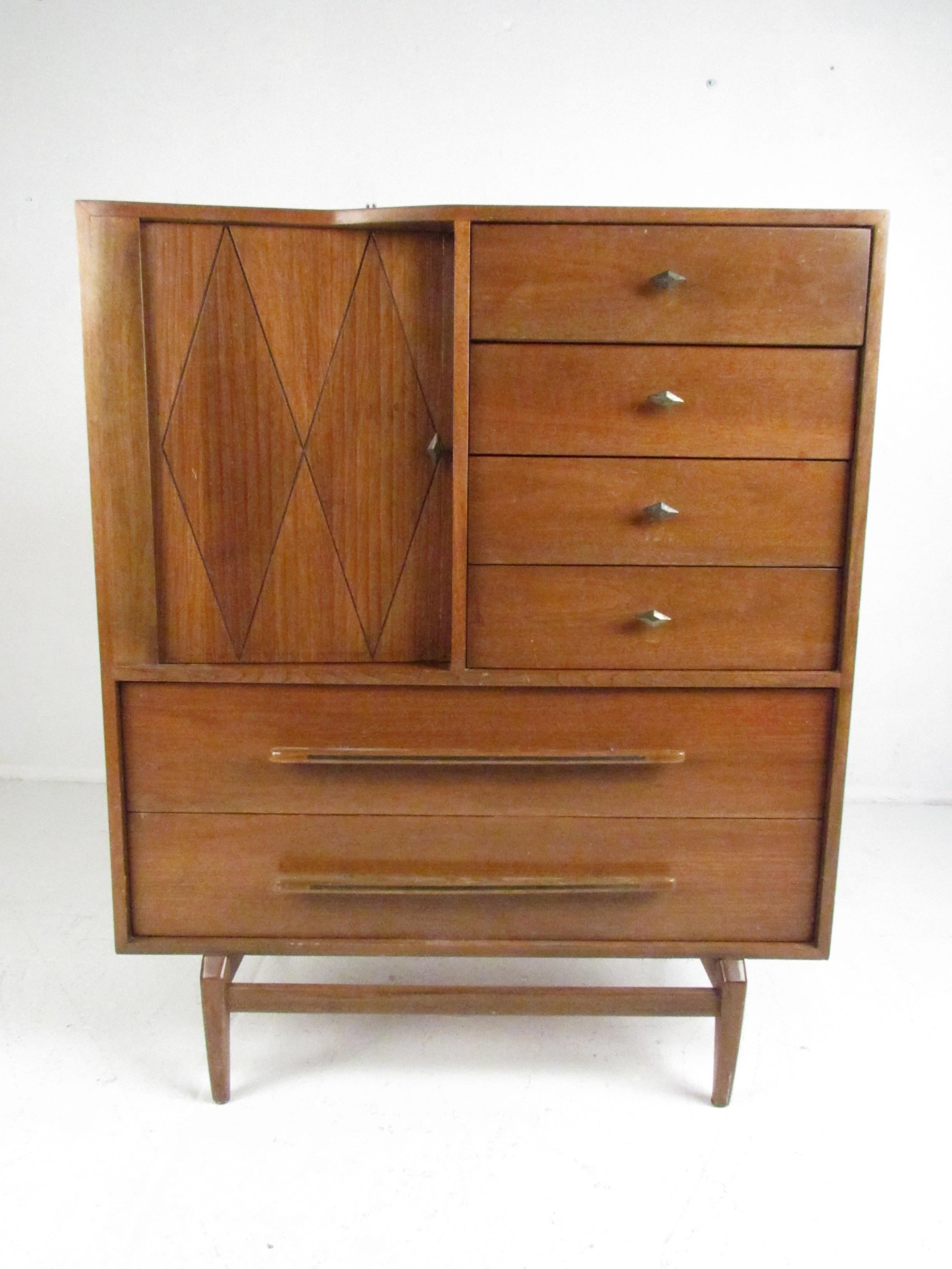 This beautiful vintage modern gentleman's chest boasts six hefty drawers and and large compartment with shelves hidden by a tambour door. A unique variety of drawer pulls, a sculpted top, and unusual angled legs add to the mid-century appeal. This