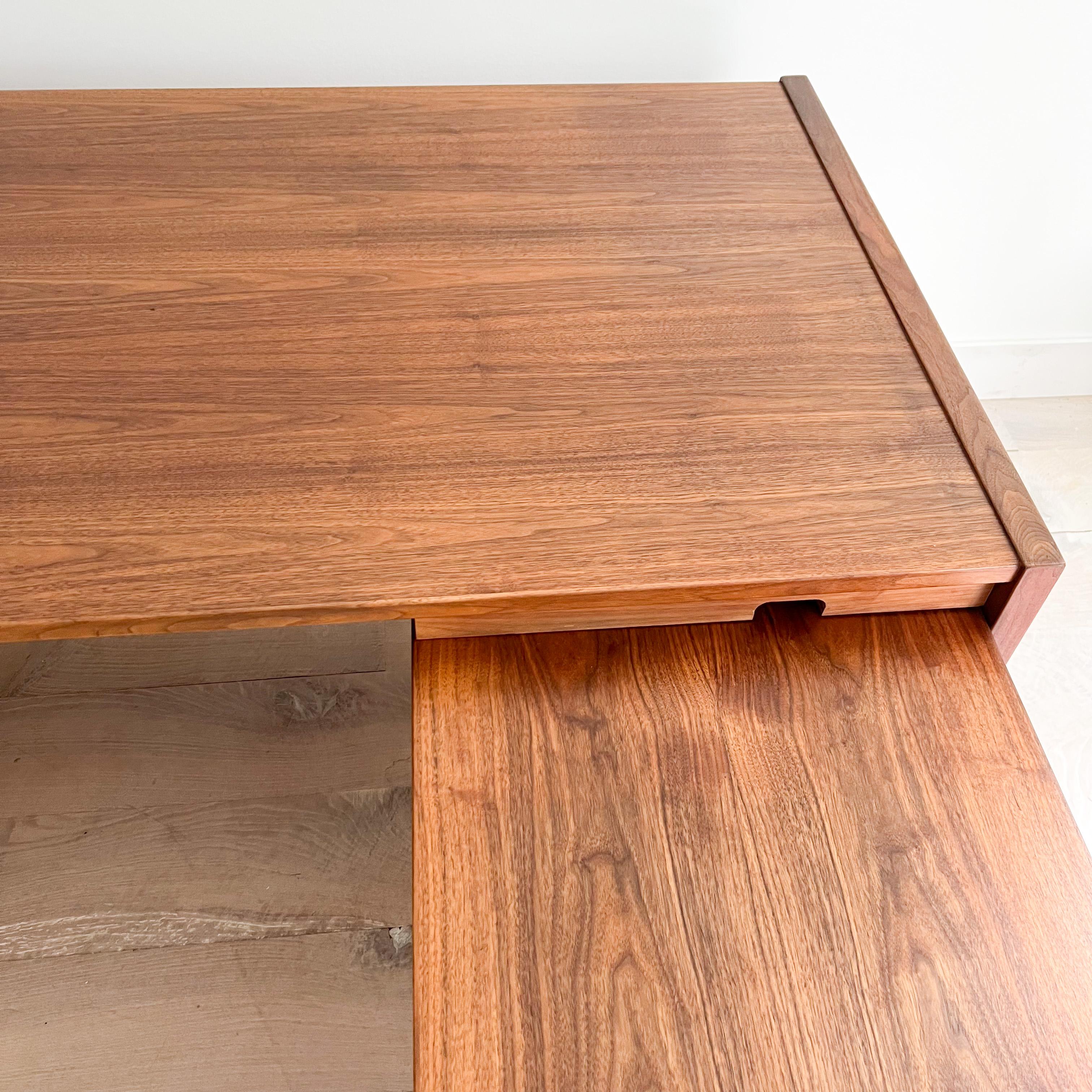 Mid century modern walnut desk with side return designed by Jens Risom. The tops have been sanded and restored. Some scuffing/scratching/small areas of veneer repair/fading from age appropriate wear. The return can be removed and the desk can be
