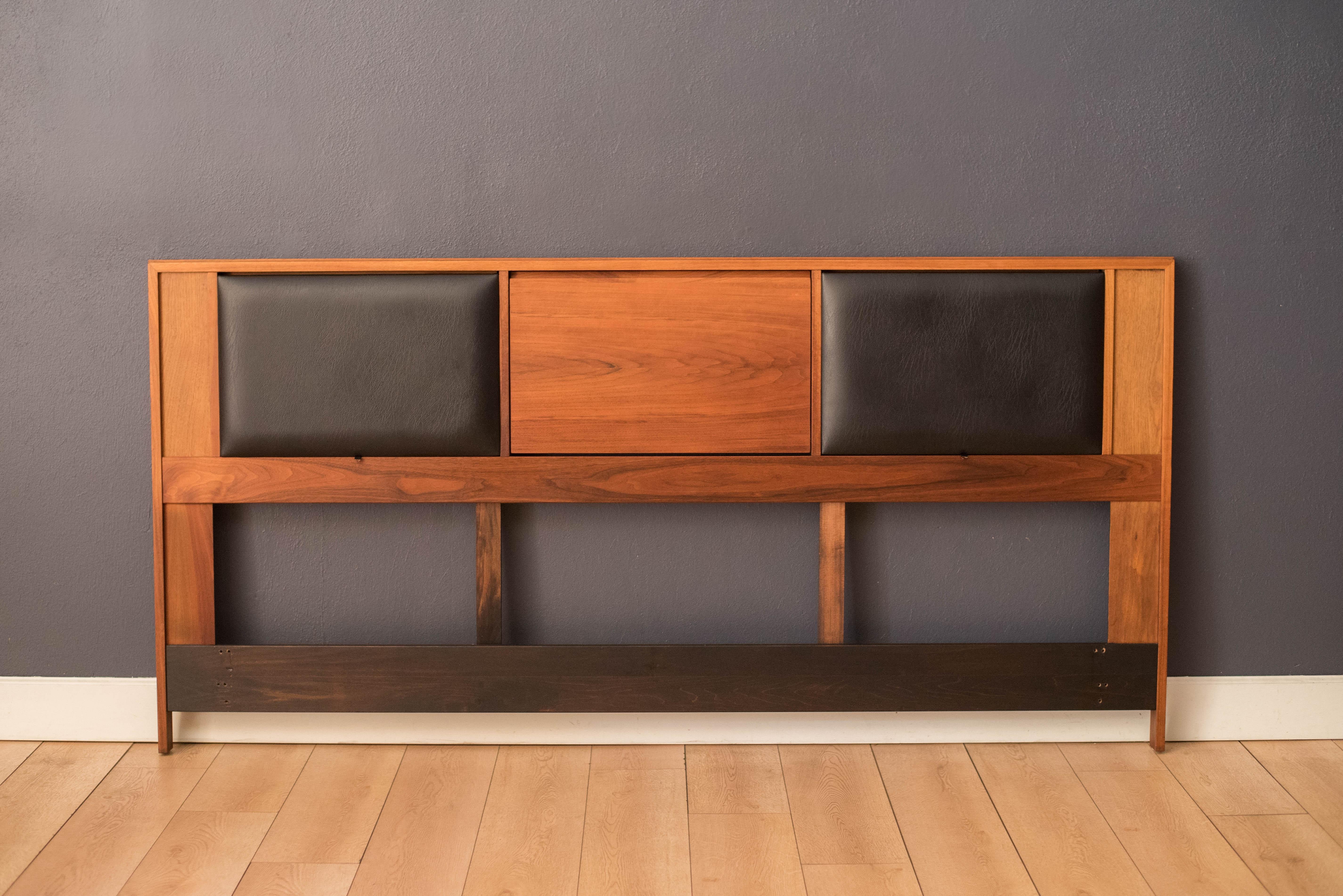 Cabecero king size moderno de mediados de siglo diseñado por John Keal para Brown Saltman de California, hacia 1960. Esta pieza muestra preciosas vetas de nogal y dos paneles de respaldo acolchados ajustables en polipiel negra. Incorpora una