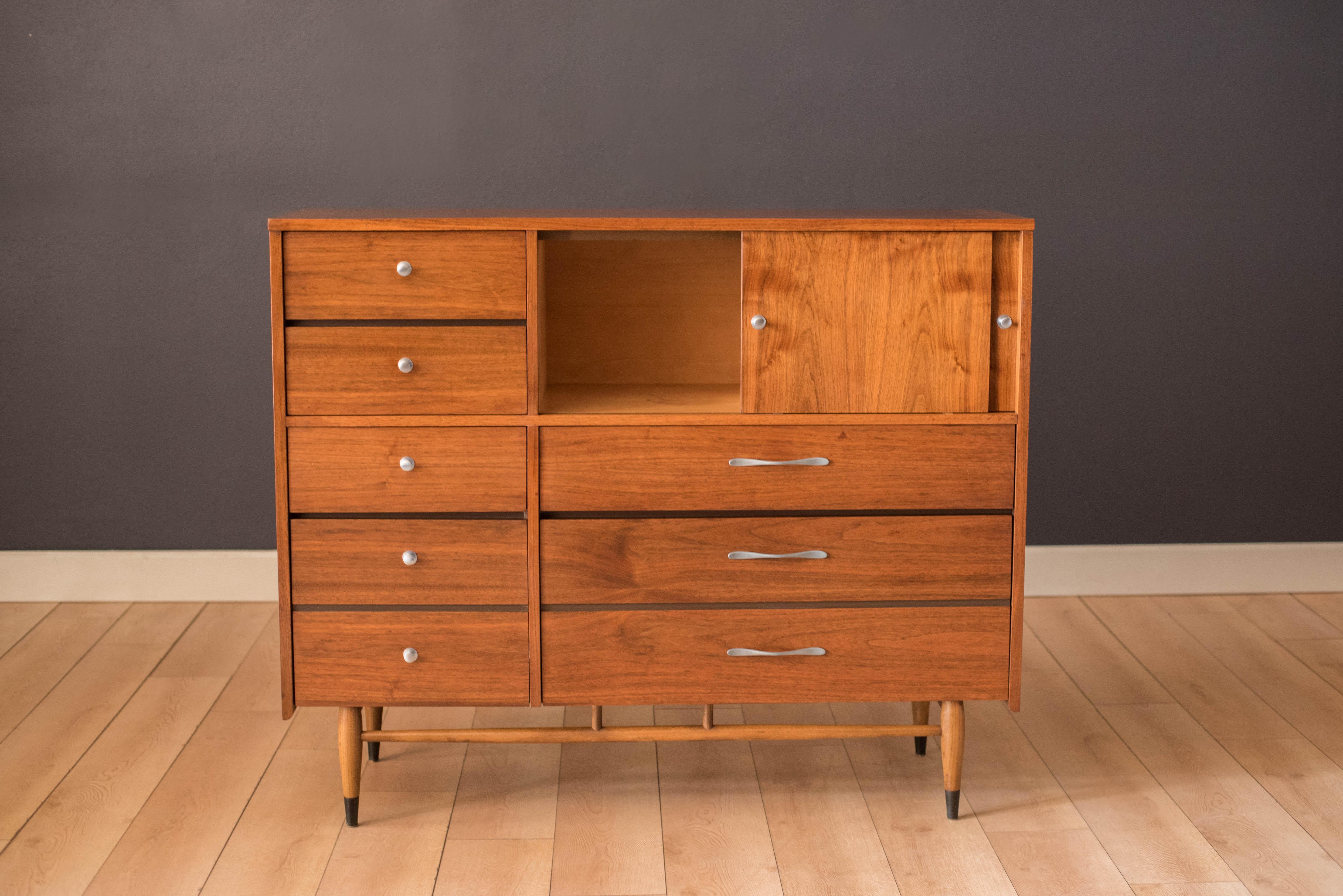 Vintage tall highboy dresser chest manufactured by Lane Furniture. This piece offers plenty of storage that includes six drawers and two organizing open compartment spaces with sliding doors. Accented with polished aluminum pulls and the Acclaim