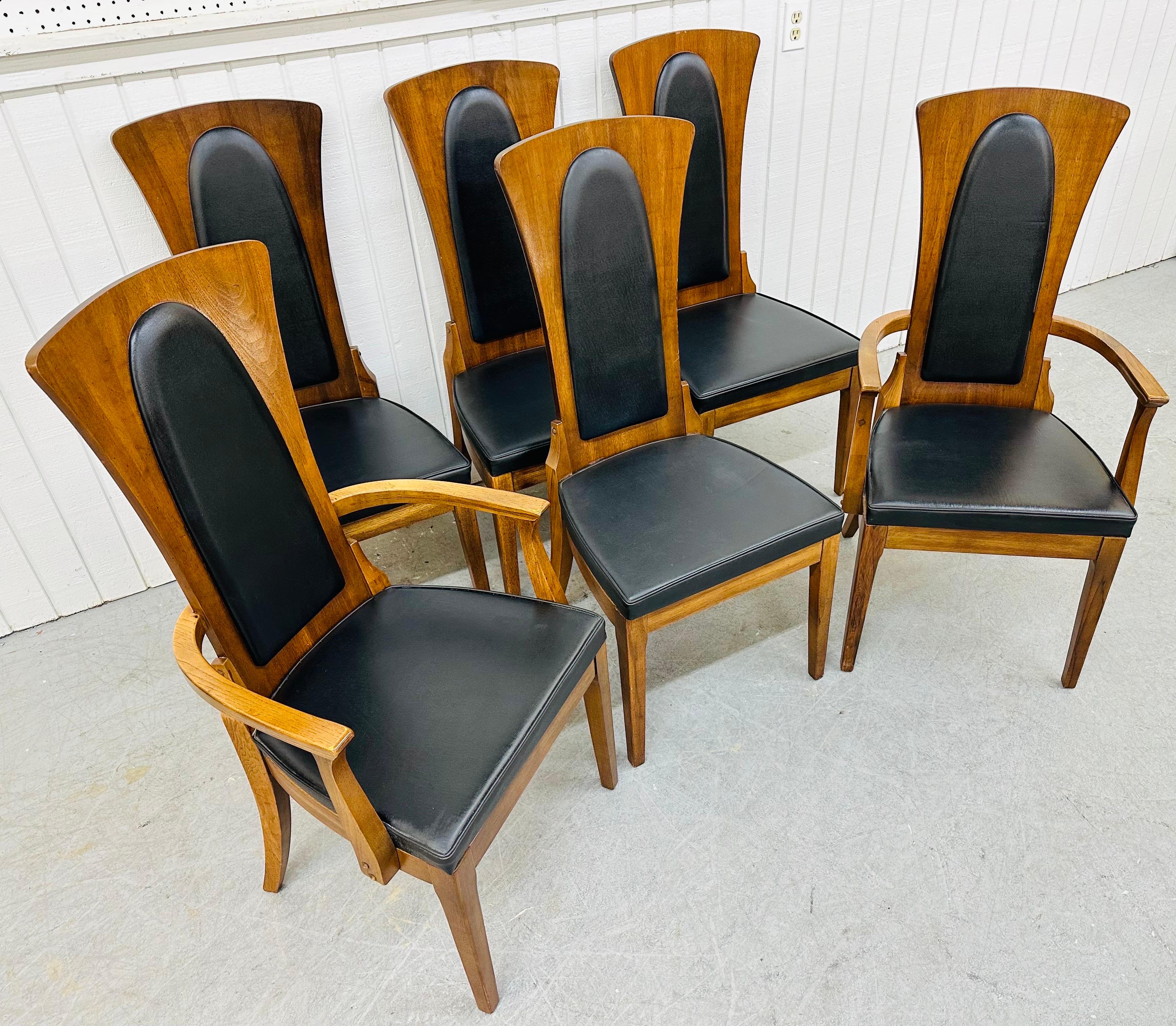 This listing is for a set of six Mid-Century Modern Walnut & Leather Dining Chairs. Featuring a high back design, two arm chairs, four straight chairs, original black leather upholstery, and a beautiful walnut finish. This is an exceptional