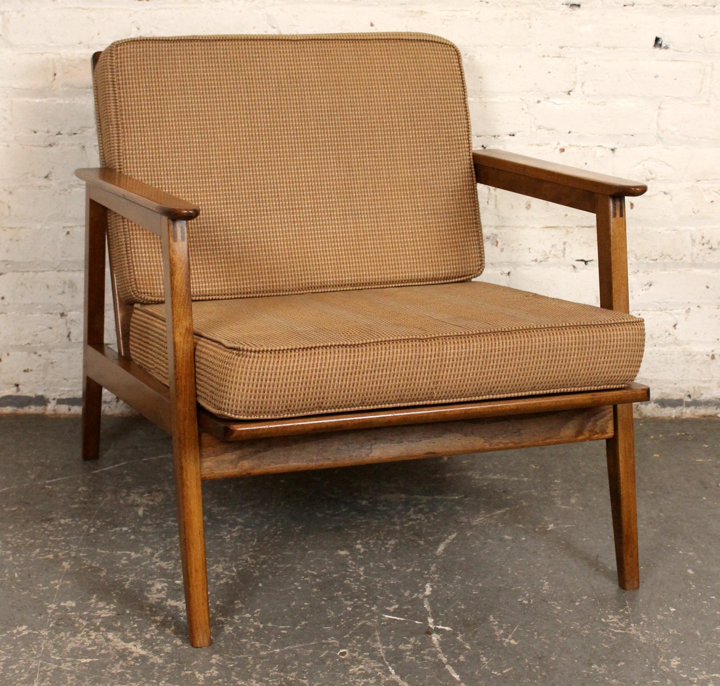 Chaise de salon à profil bas en noyer massif avec assemblage à entures multiples et dossier en fuseau. Le dossier incliné offre une position allongée agréable et confortable, avec un siège à sangles en caoutchouc. Fabriqué pour le confort et la