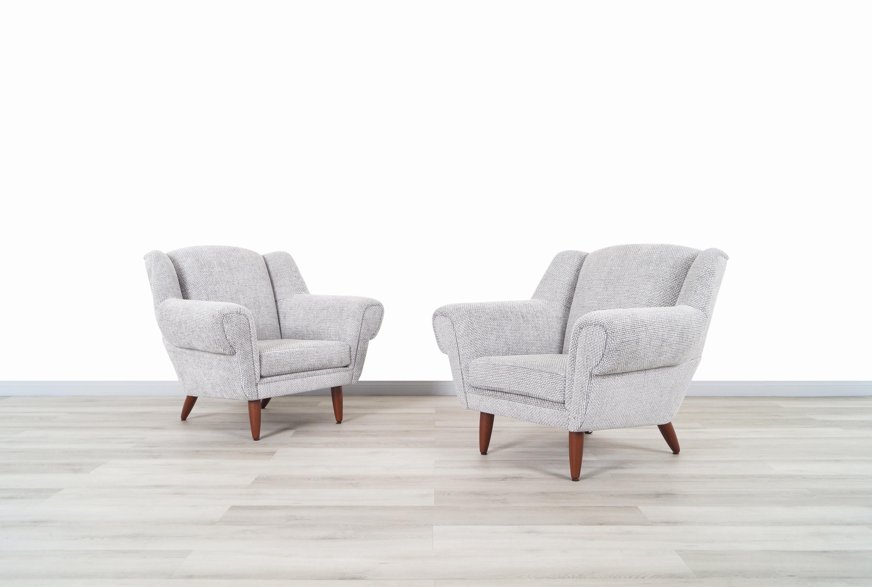 A pair of beautiful Mid-Century Modern lounge chairs manufactured in Denmark, circa 1960s. Feature a cozy feel and a number of curved details that give the pieces a delightful sculptural design. Each chair sits on four solid walnut thick rounded