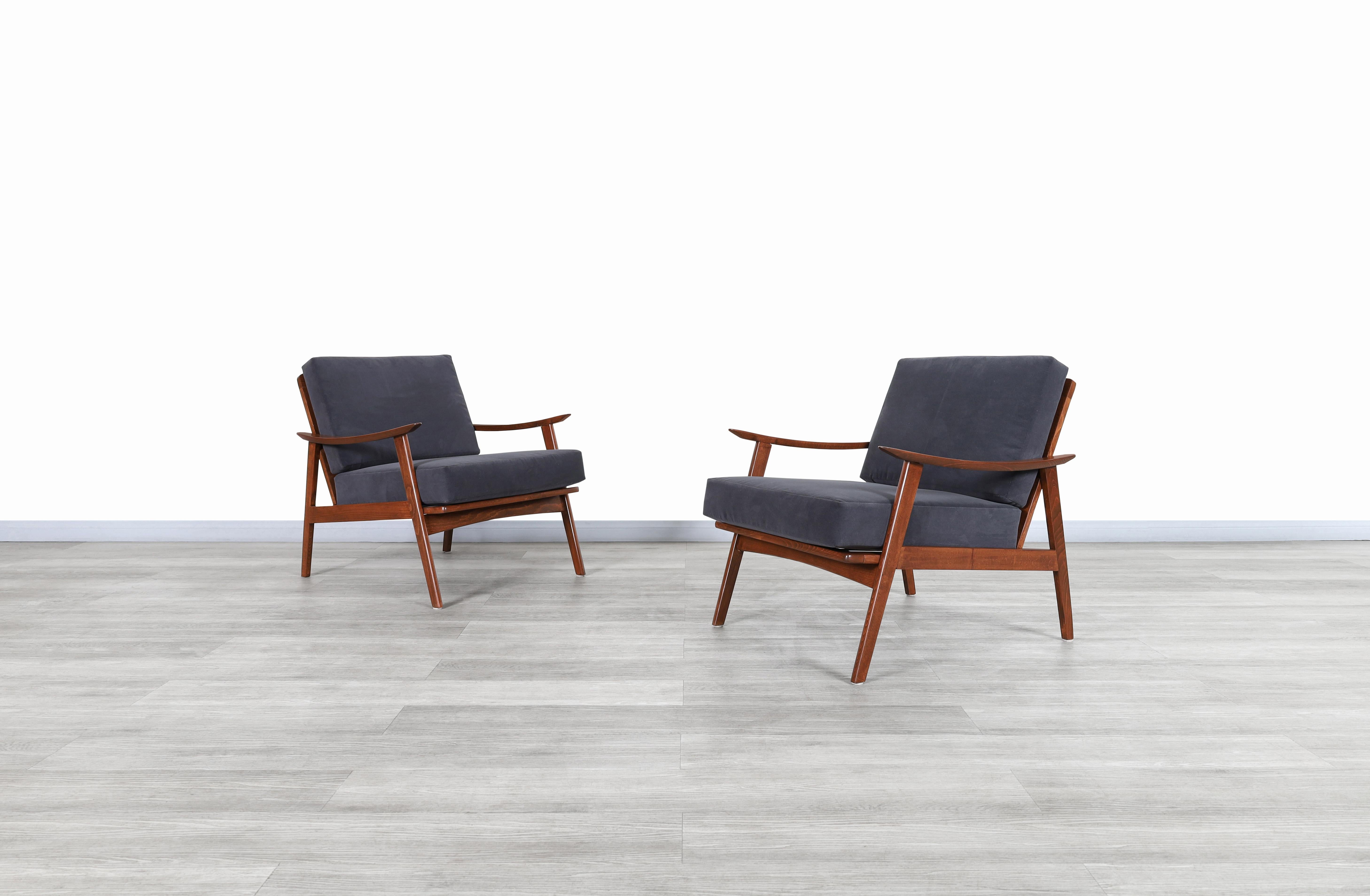 Fabulous Mid-Century Modern walnut lounge chairs designed and manufactured in United States, circa 1950s. These chairs have a great distinctive design for their era. Our skilled artisans have completely restored each chair. They feature